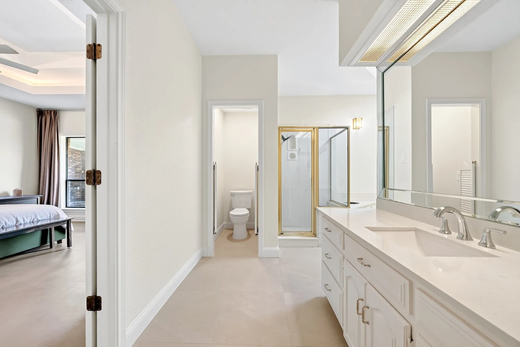 Dual vanity with an integrated sink, polished chrome fixtures, and a large wall-mounted mirror
