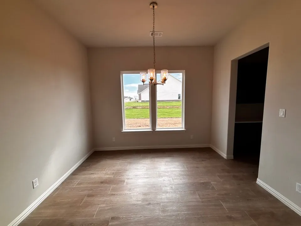 Recessed walls, wood-finish flooring, and a contemporary chandelier