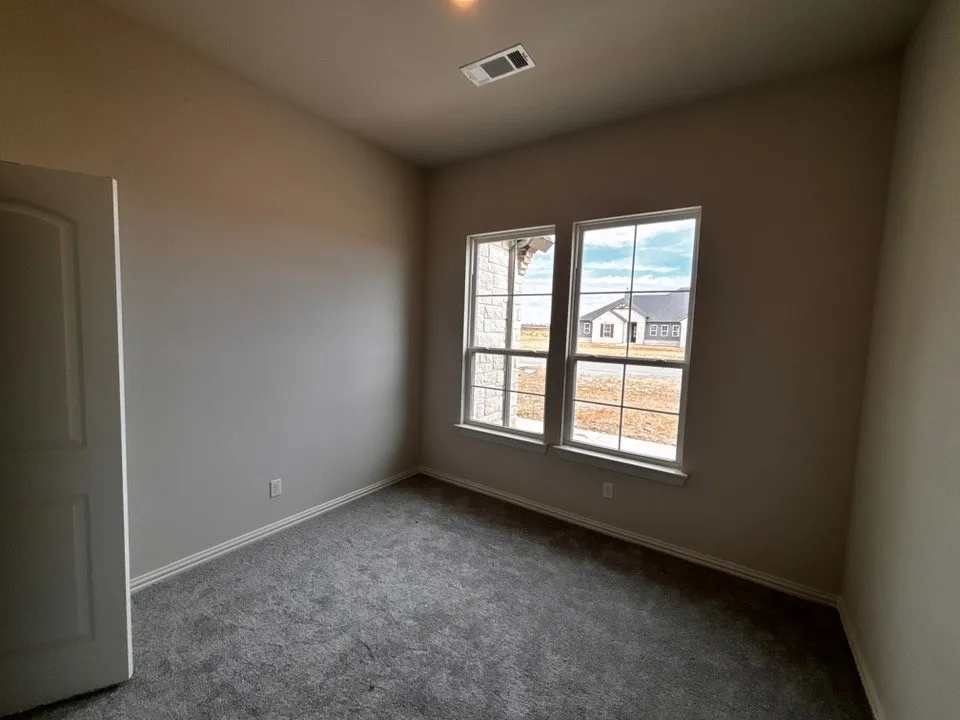 Neutral wall tones, carpeted flooring, and a pair of windows