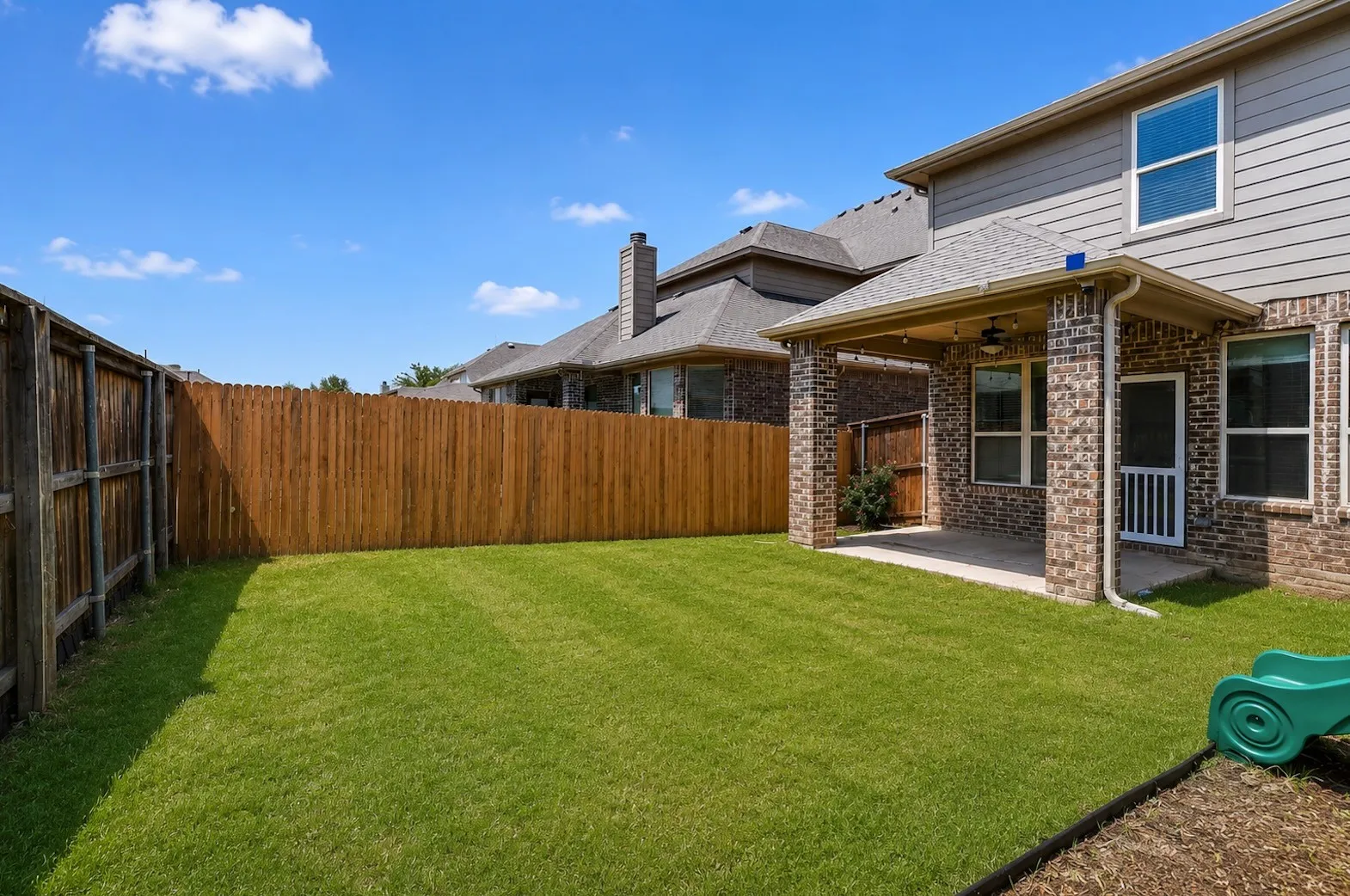 Expansive green lawn with a wood privacy fence