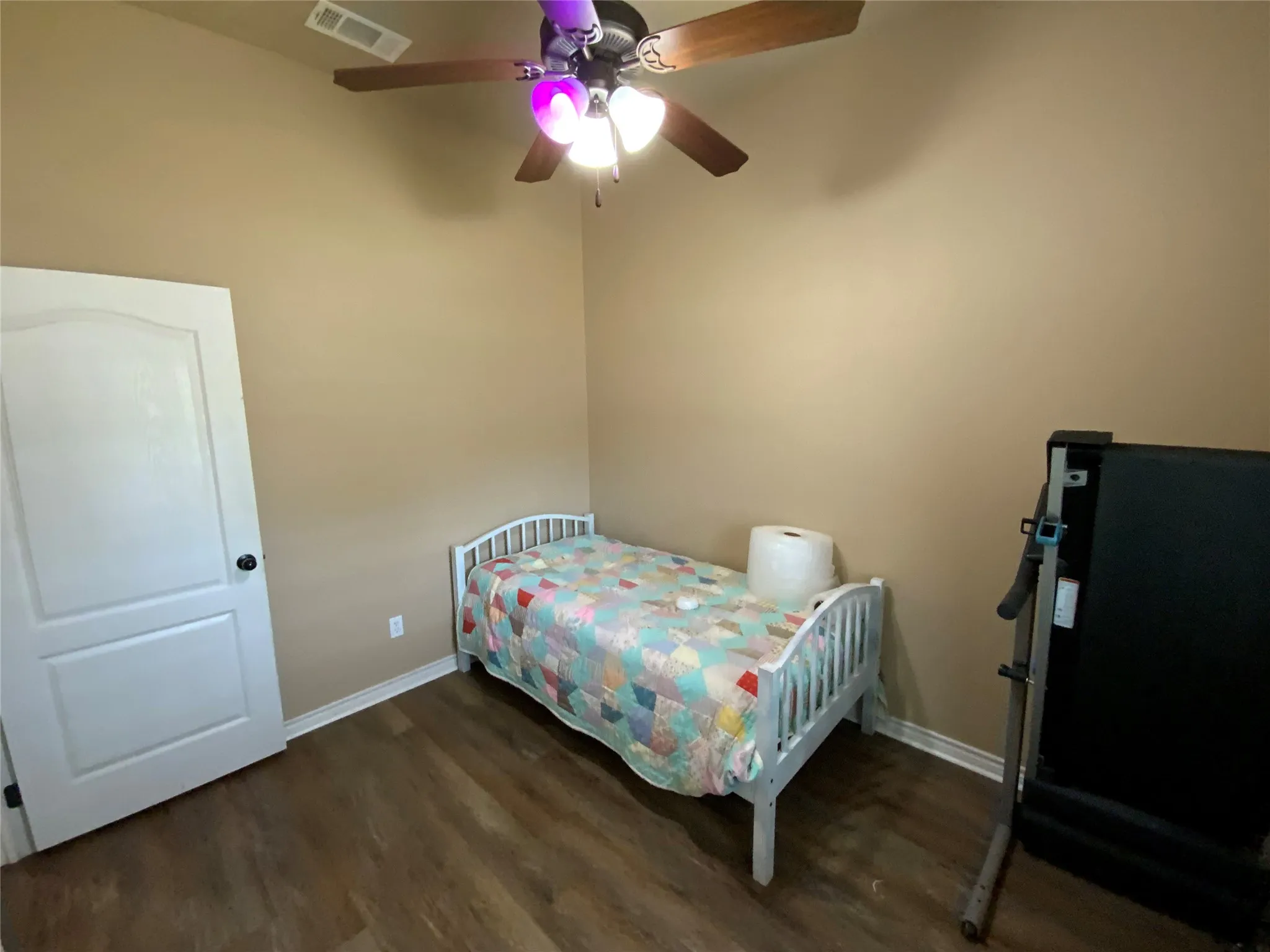 Wood-finish flooring, neutral wall tones, and a ceiling fan with integrated lighting