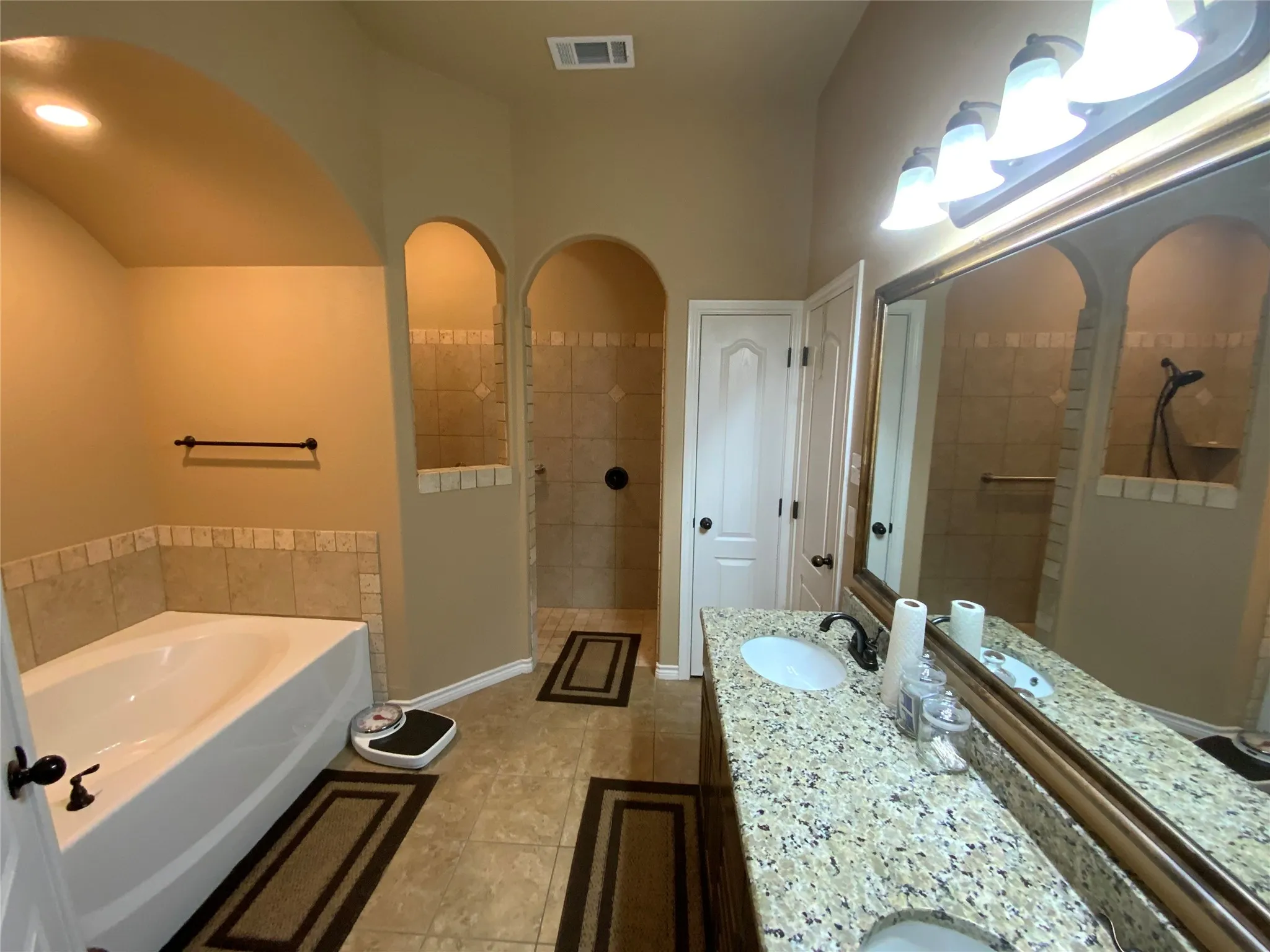 Dual vanity with stone-finish countertop, undermount sinks, and dark-finish fixtures