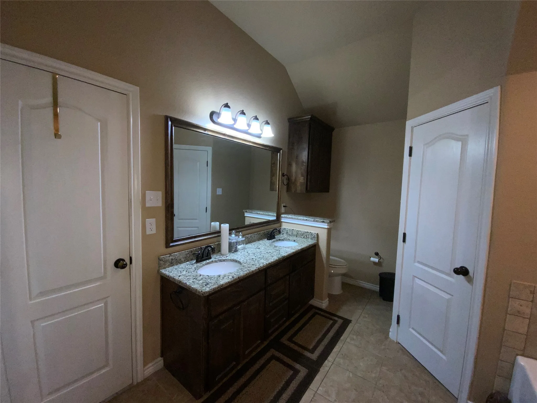 Dual vanity with undermount sinks, granite-style countertop, and wood-finish cabinetry