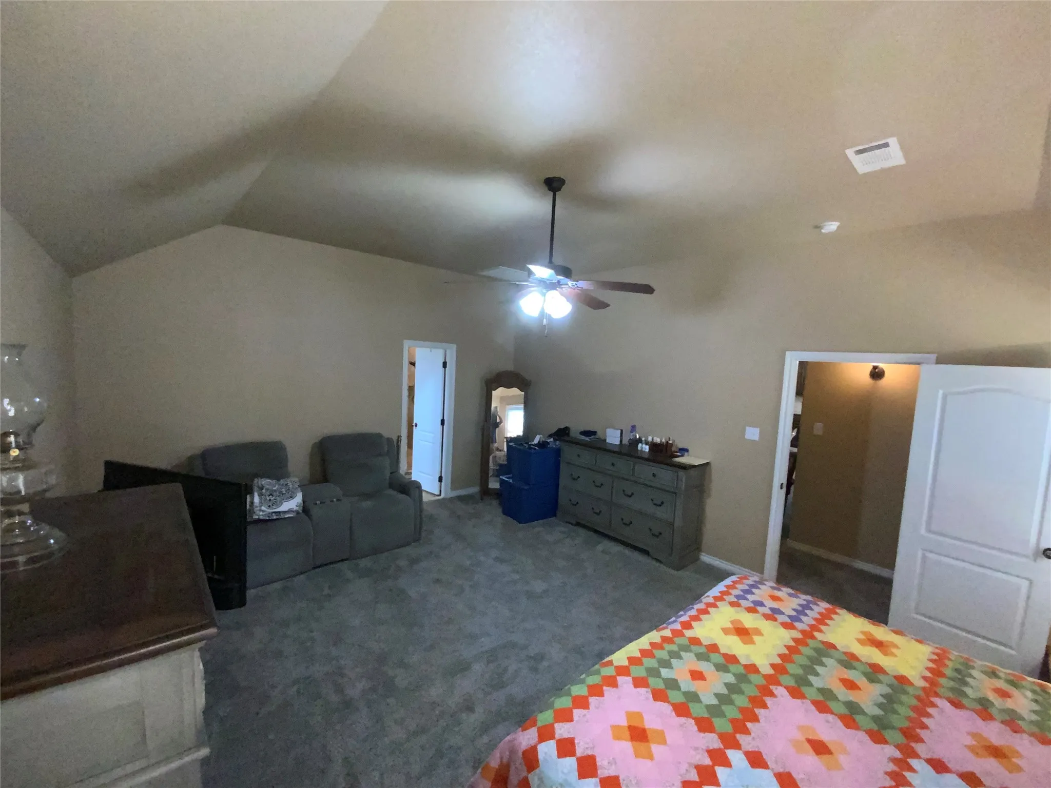 Vaulted ceiling, ceiling fan, and painted walls