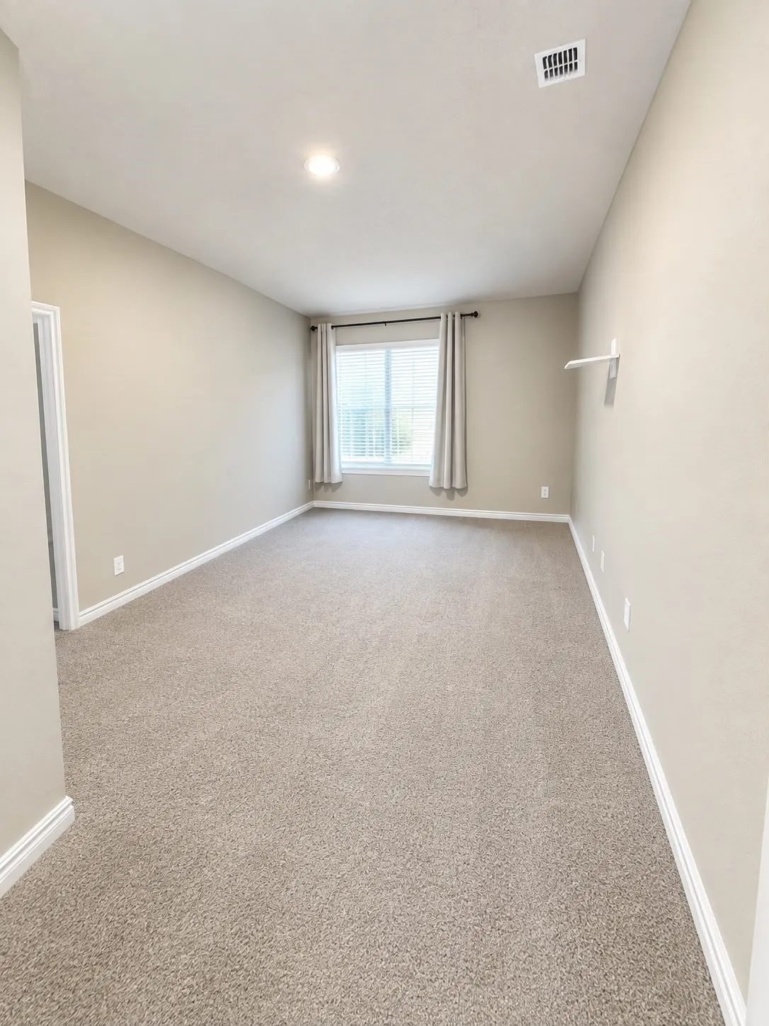 Plush carpet flooring, neutral paint tones, recessed ceiling lighting, and a window with blinds