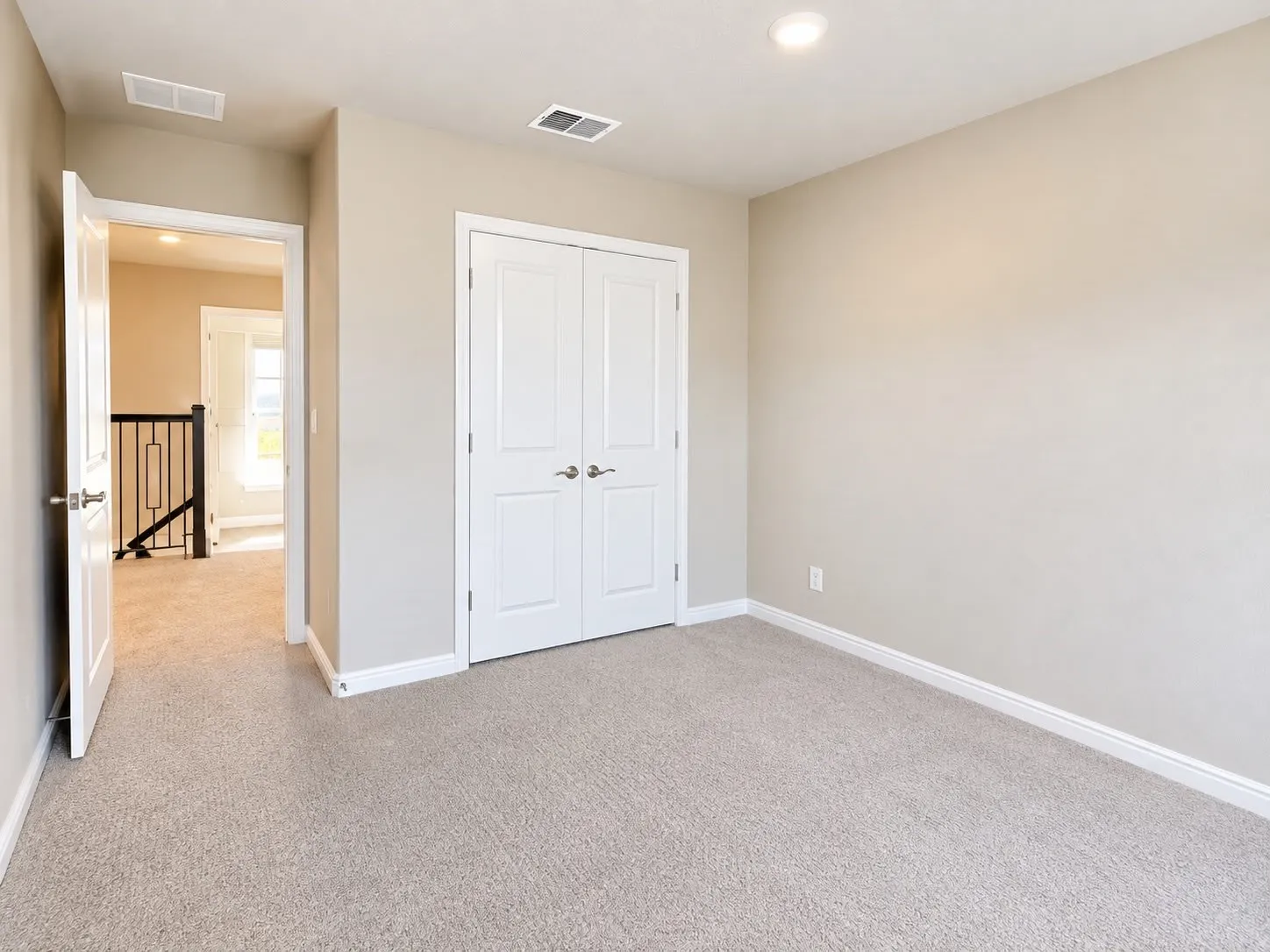 Neutral-toned carpeting throughout, recessed ceiling lighting, and white trim