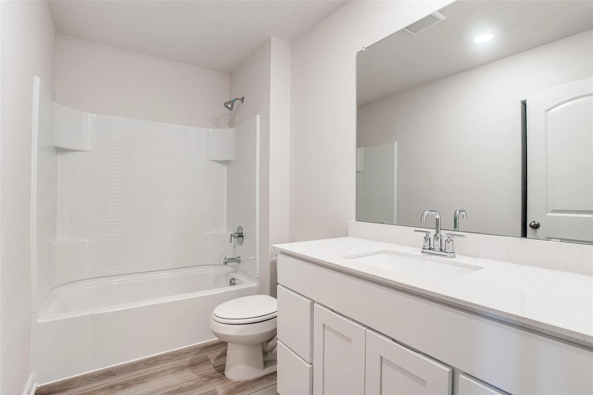 Bathroom featuring a white vanity with shaker-style cabinetry, a built-in sink, and a large mirror