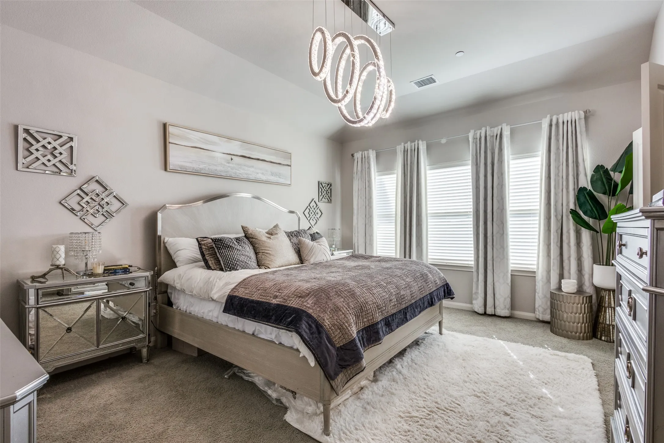 Recessed lighting, contemporary chandelier, multiple windows with blinds, and carpeted flooring