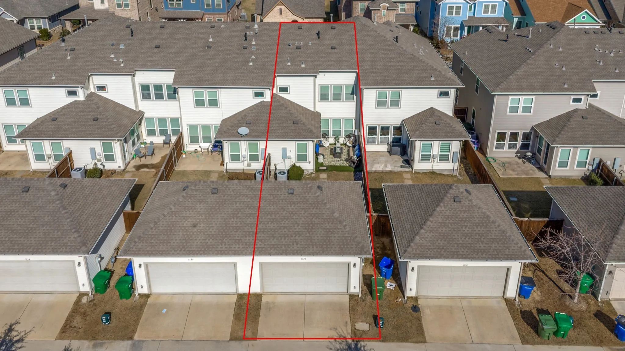 Rear elevation featuring multiple windows and a paved patio area