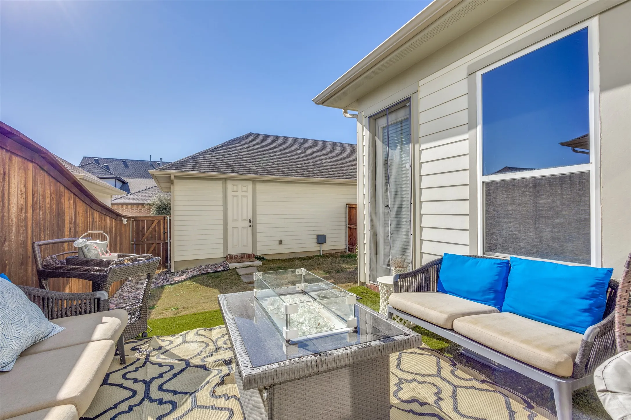Patio area featuring a sliding glass door, fixed glass window, and a built-in outdoor fire pit
