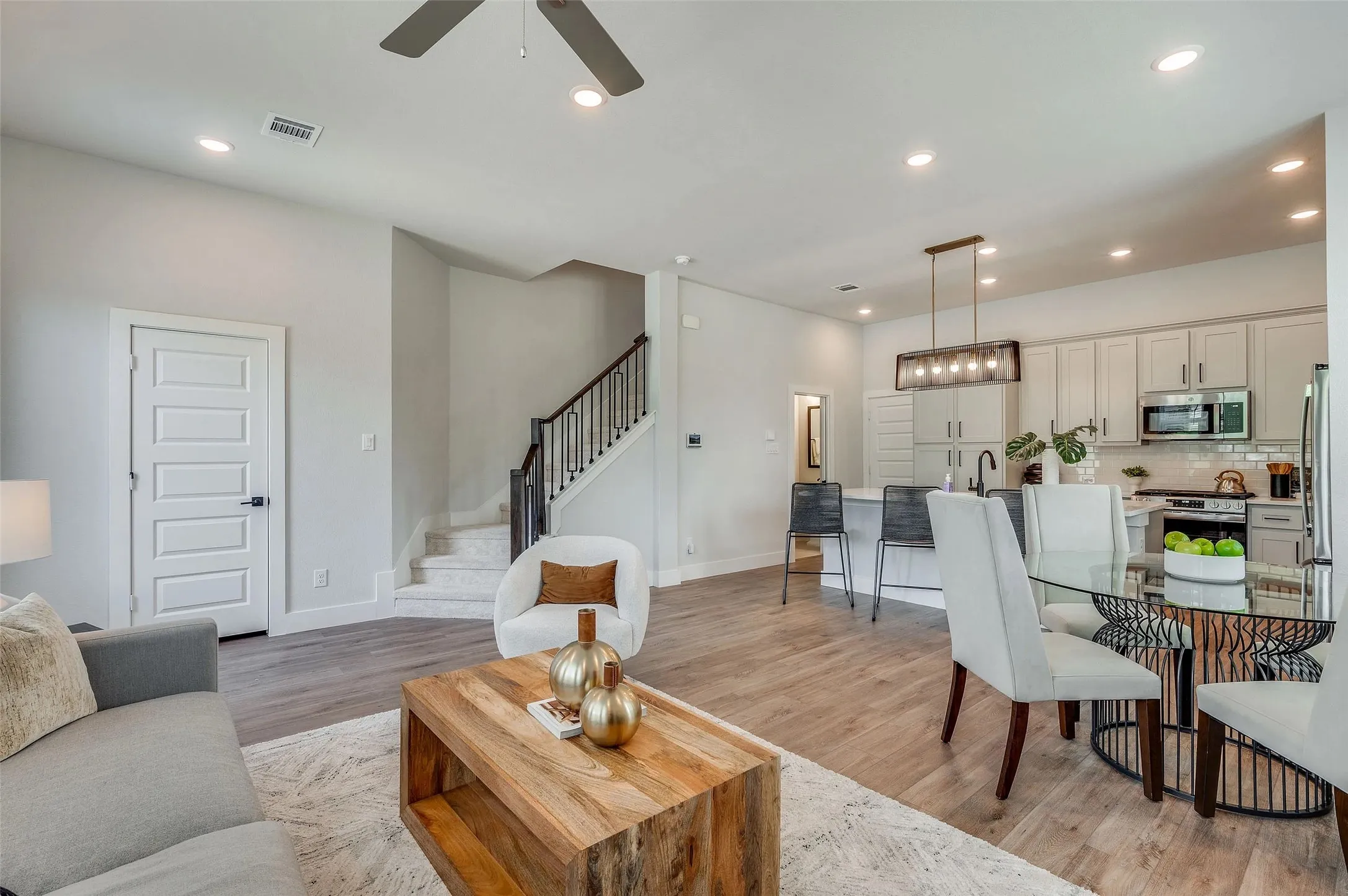 Open-concept layout with wood-finish flooring, recessed lighting, and a modern ceiling fan