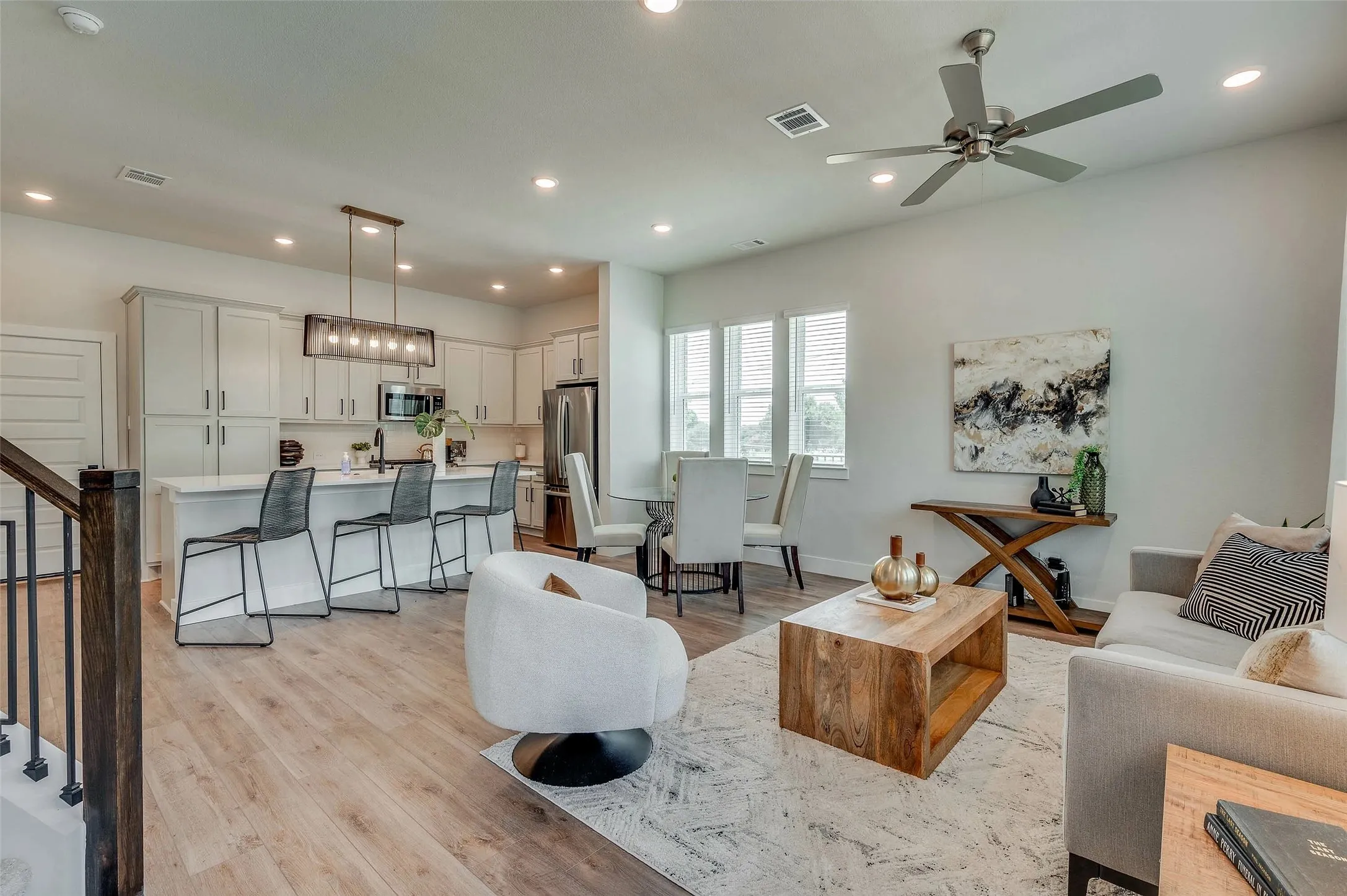 Open-concept living space featuring wood-finish flooring, recessed lighting, and a contemporary ceiling fan