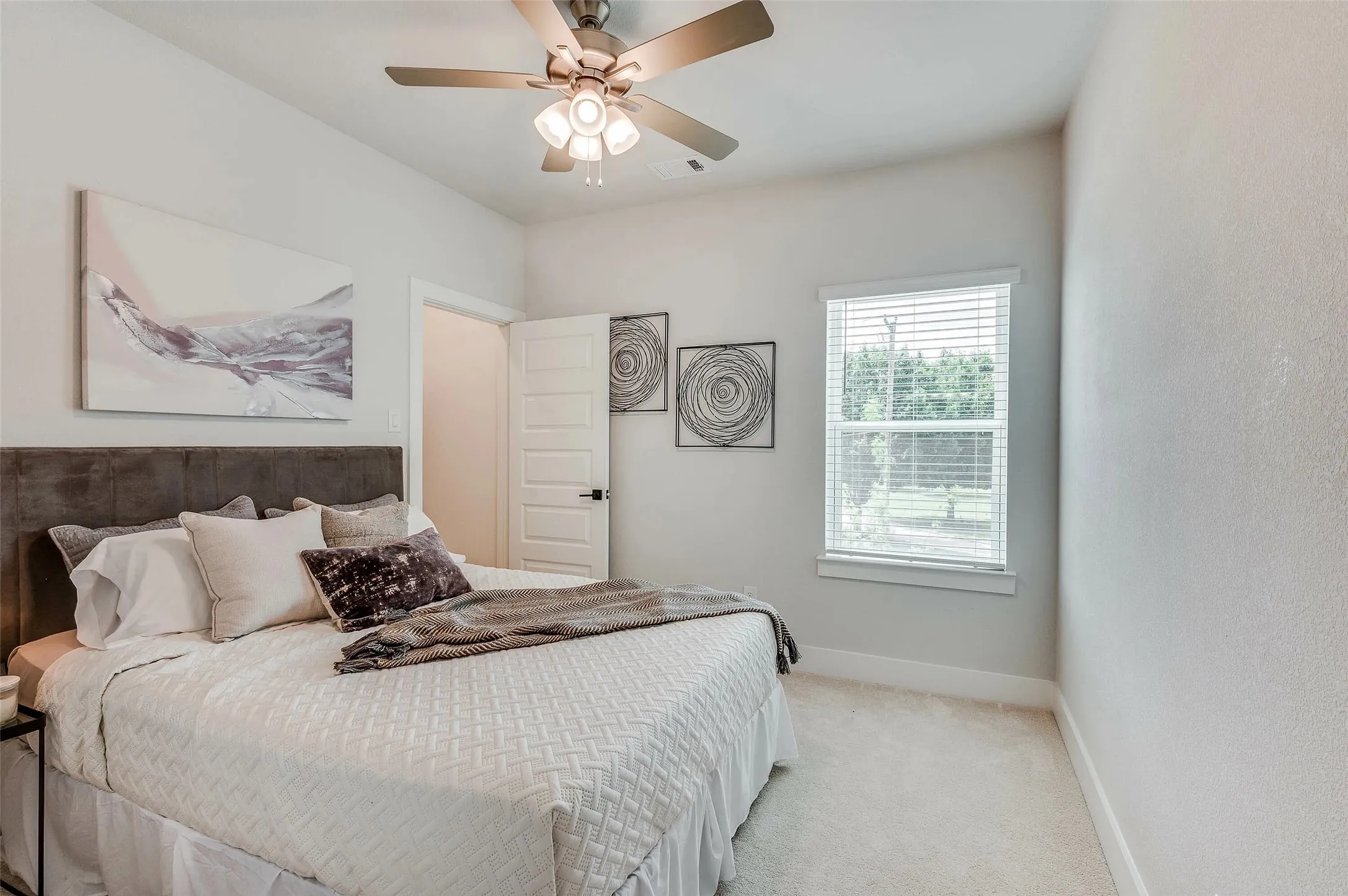 Bedroom featuring a ceiling fan with integrated lighting, carpeted flooring, and a window with blinds