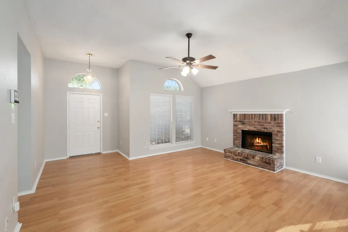 living room has ceiling fan, cozy fireplace and nice windows with privacy solar screens to keep you cool
