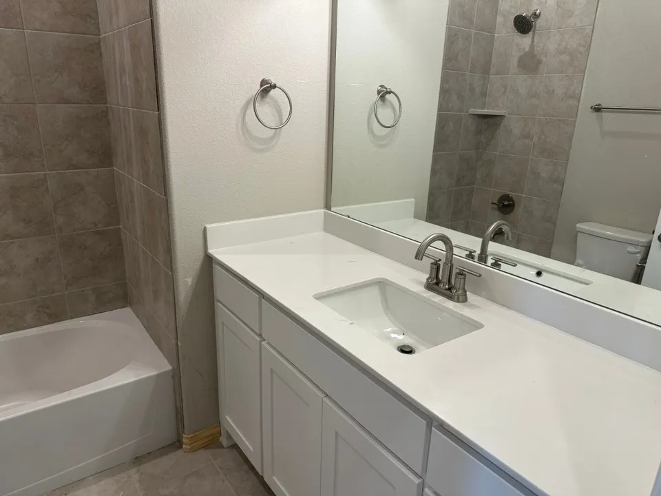 Vanity with white shaker cabinetry, white countertop, and integrated rectangular sink