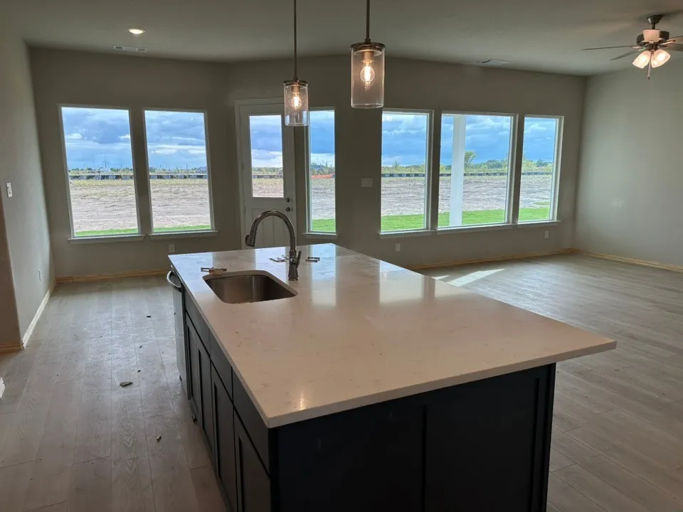 Kitchen island featuring a single-bowl stainless steel sink, gooseneck faucet, and light-toned countertop