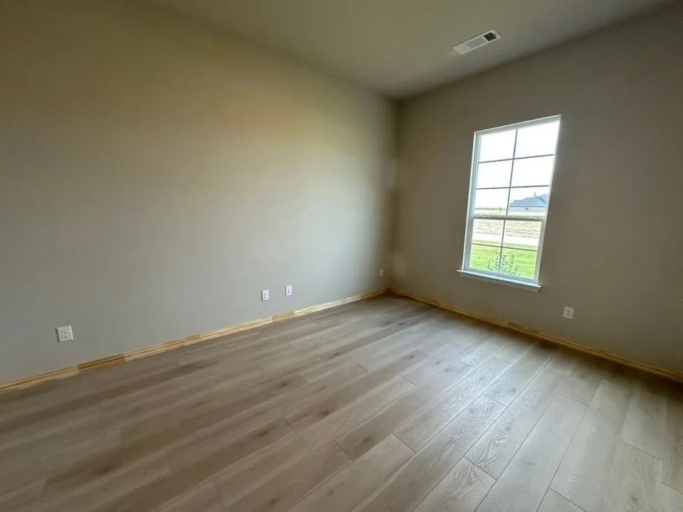 Wood-finish flooring, neutral wall tones, and a window with grid detailing