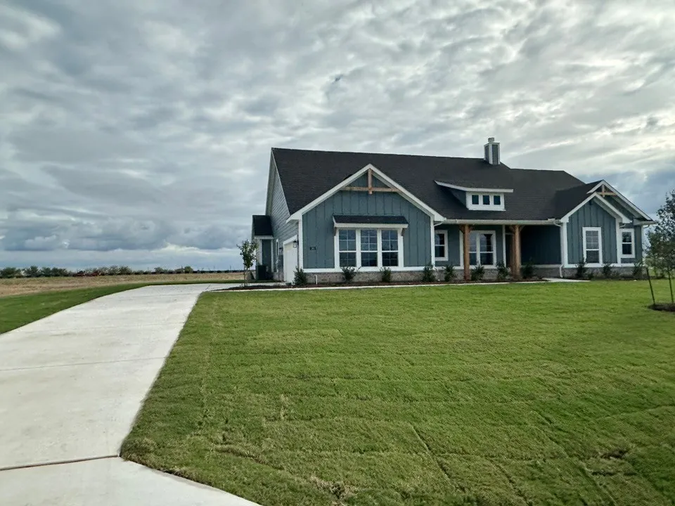 Single-story residence featuring a dark-toned roof, light blue siding, and white trim accents