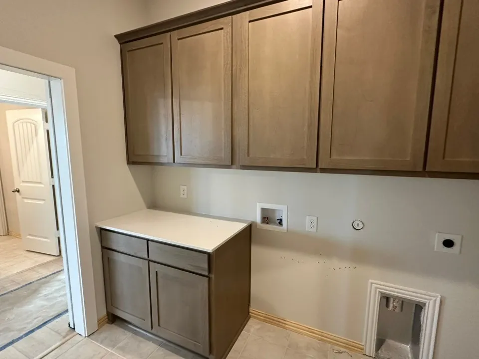 Light-toned cabinetry with crown molding and a countertop