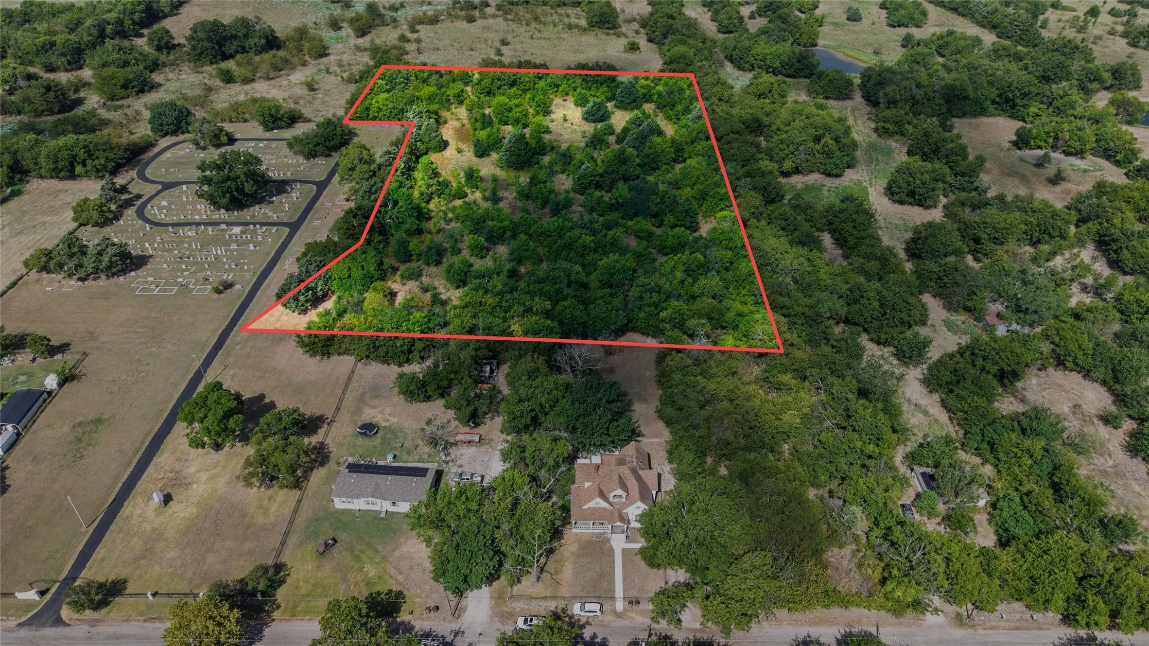 Expansive land parcel with abundant mature trees and varied topography