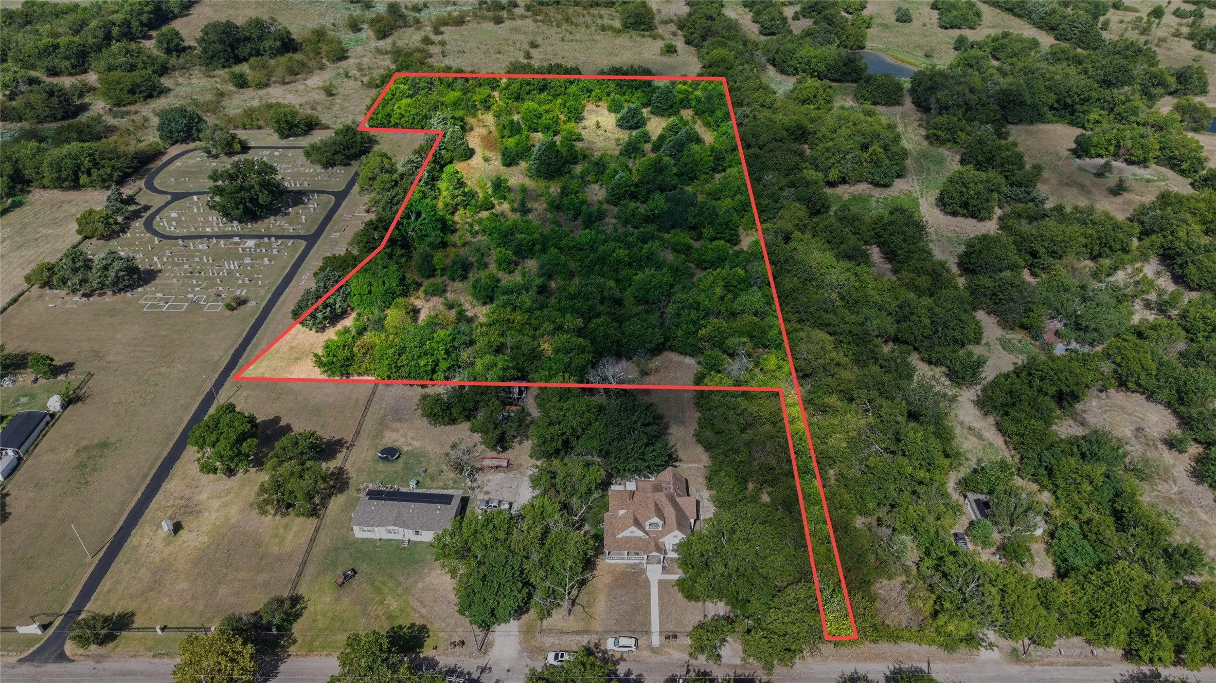 Expansive land parcel featuring a mix of open areas and dense tree cover