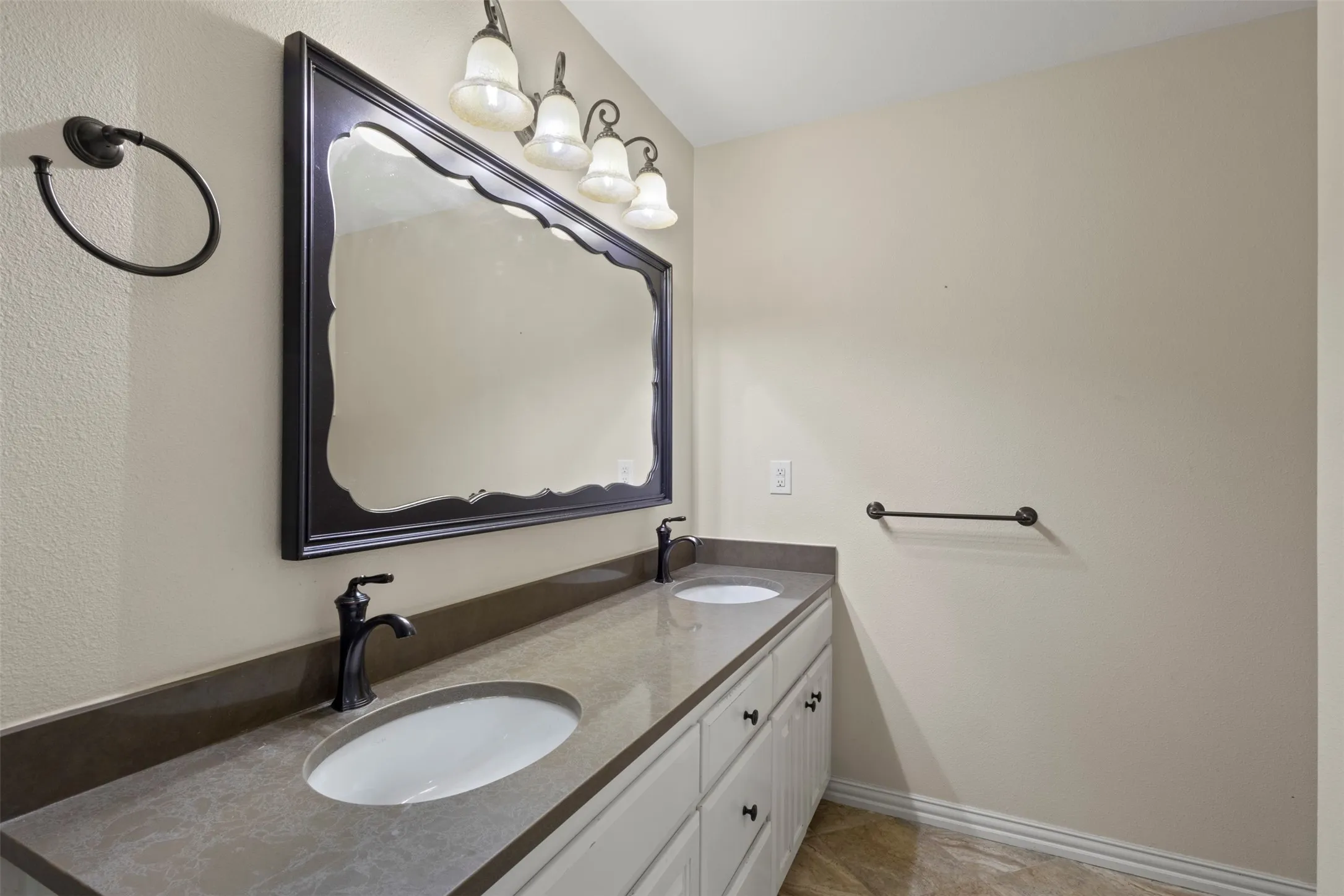 Double vanity with gray stone countertop, dual undermount sinks, and matte black fixtures