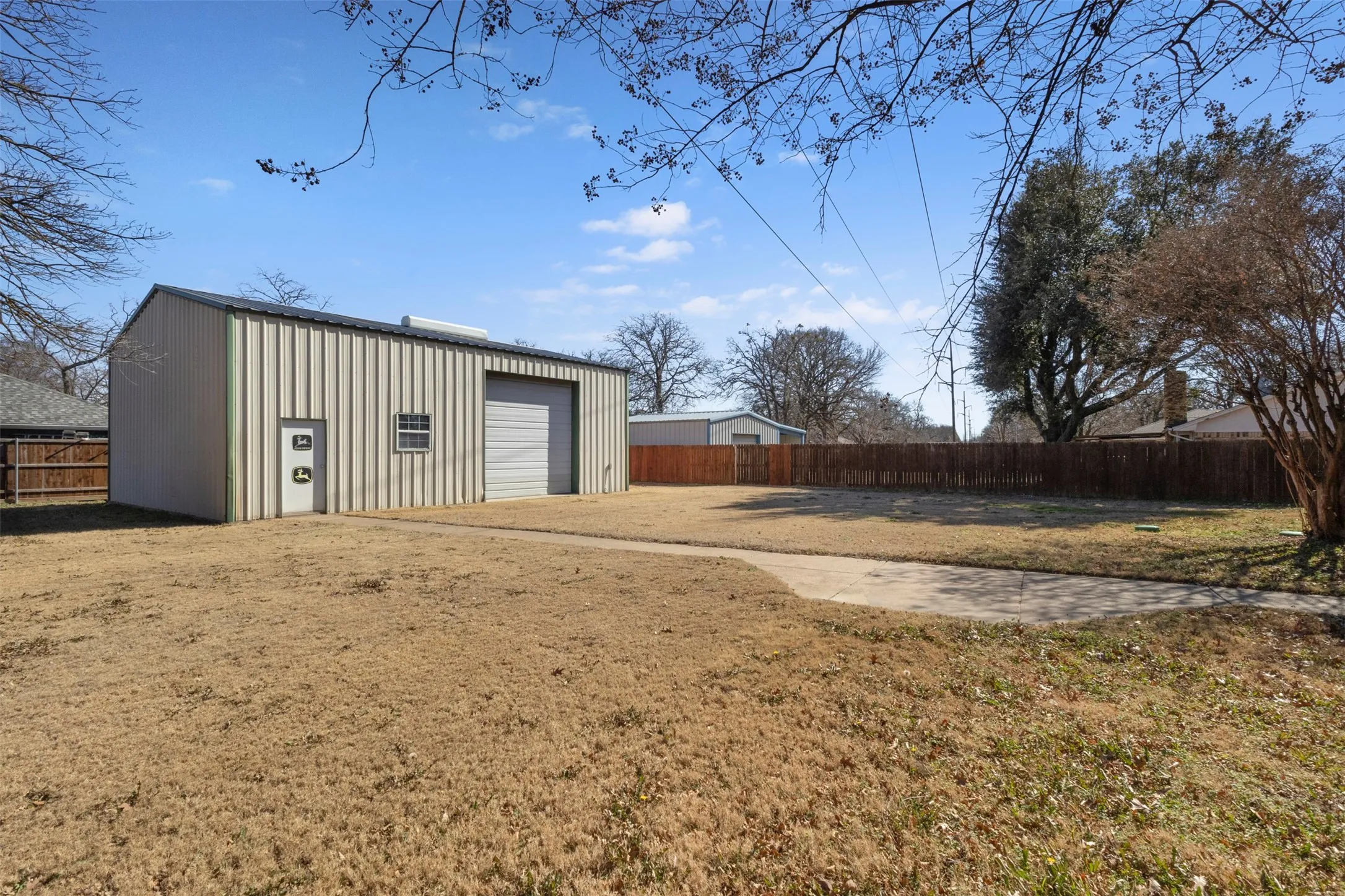 Detached metal building with a roll-up garage door, side entry door, and a single window
