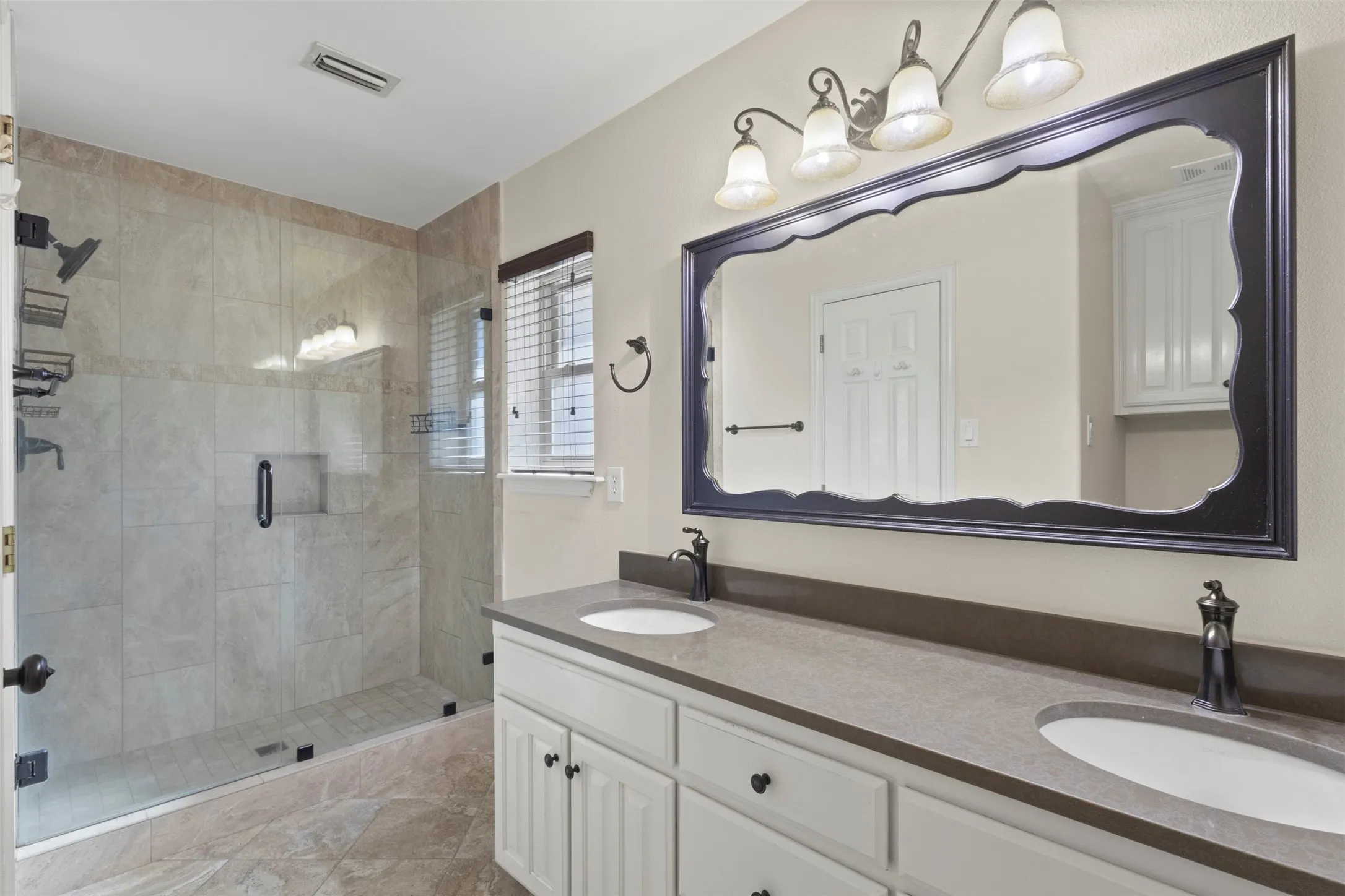 Frameless glass-enclosed shower with tiled walls and a built-in niche