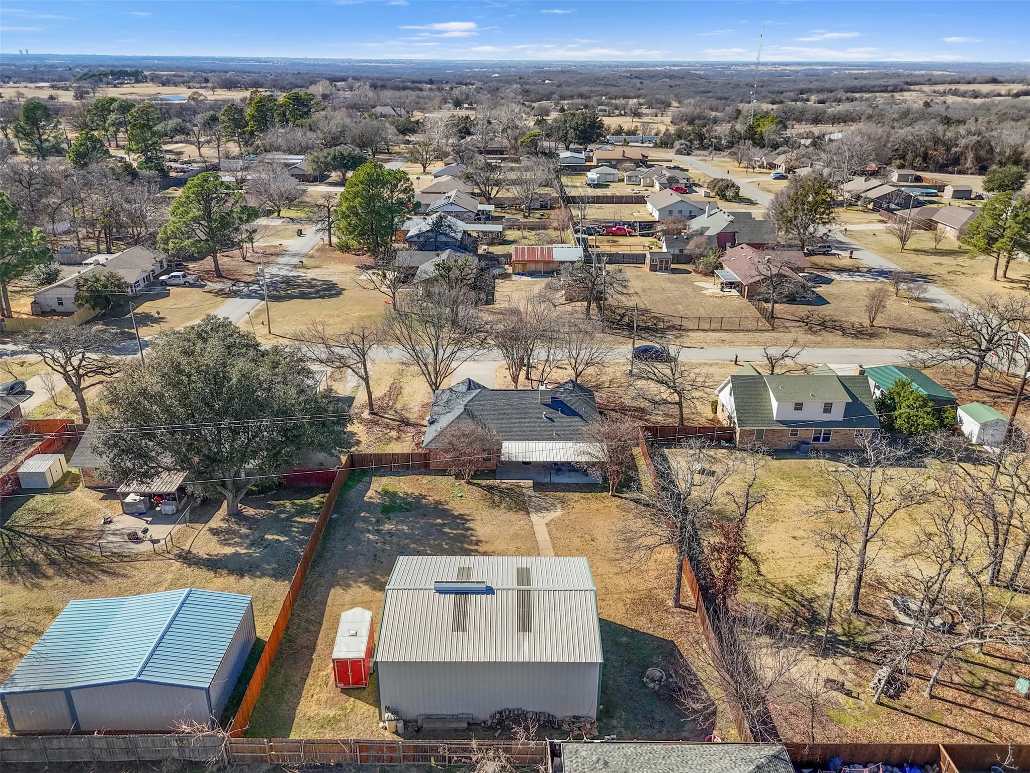 Expansive property featuring a large metal outbuilding and a fenced perimeter