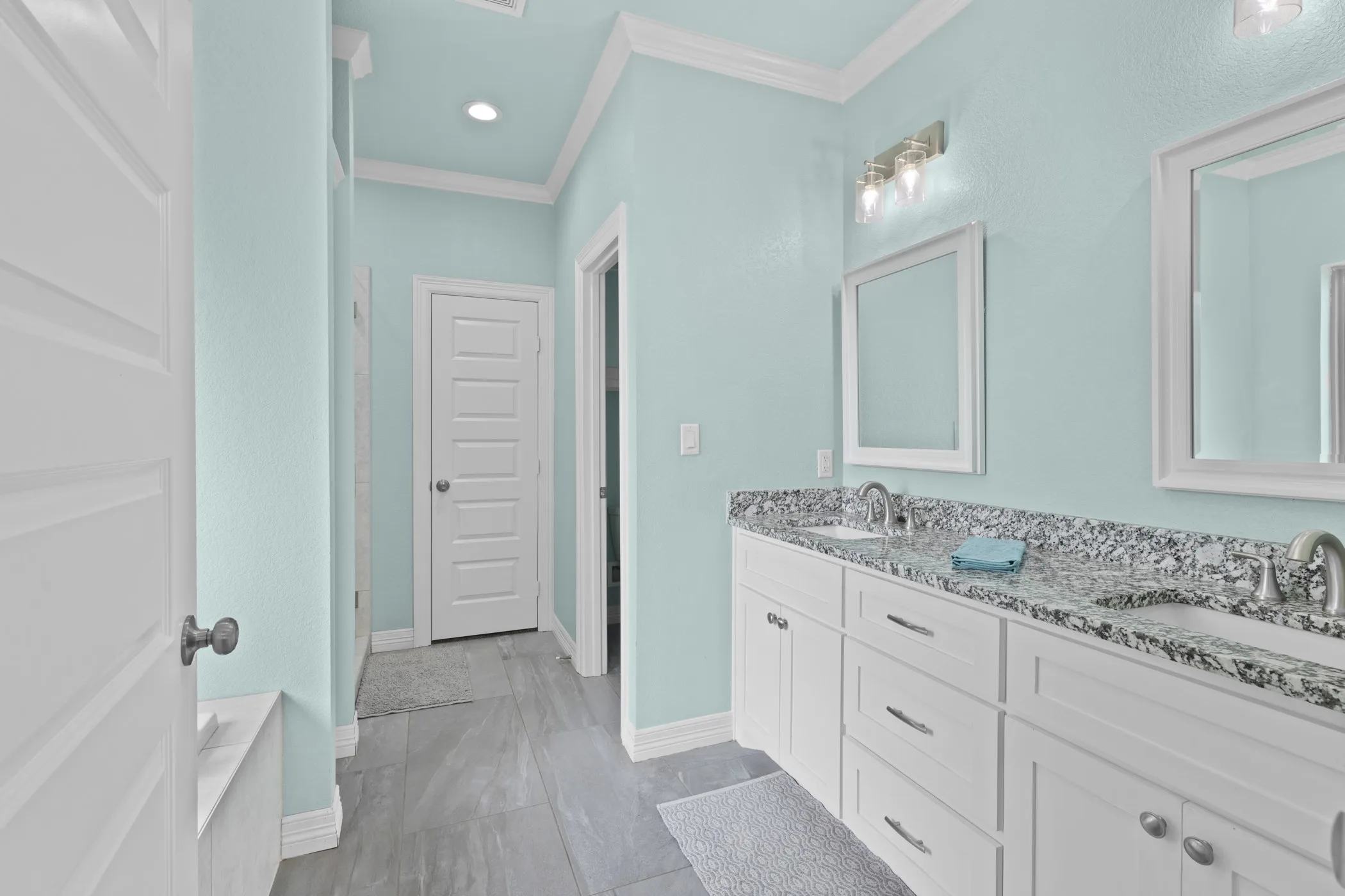 Double vanity with undermount sinks and speckled stone countertop