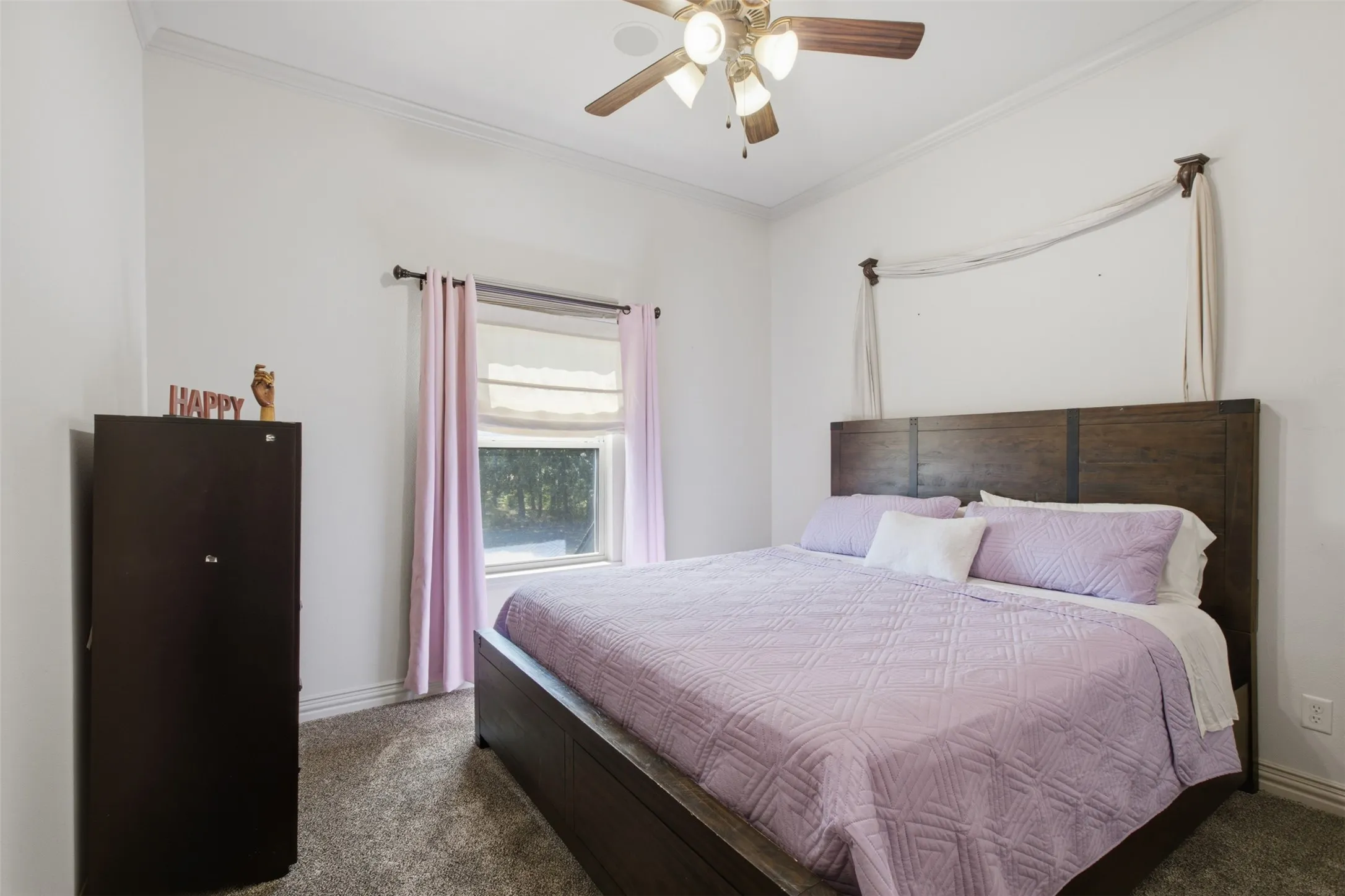 Recessed window with a roller shade, wood-finish ceiling fan with integrated lighting, and crown molding