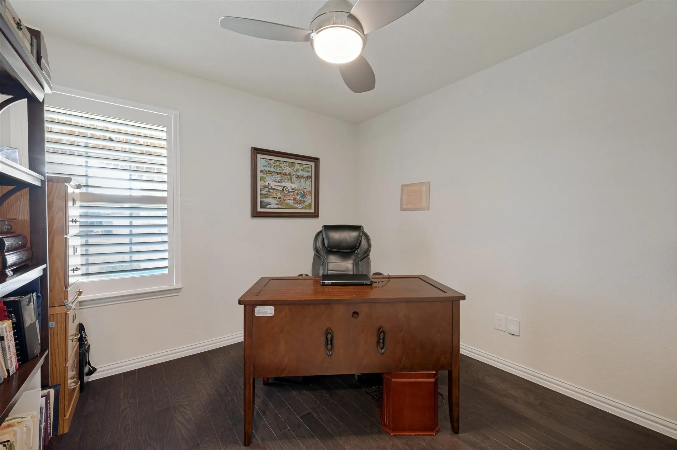 Dark wood-finish flooring, white walls, and a window with blinds