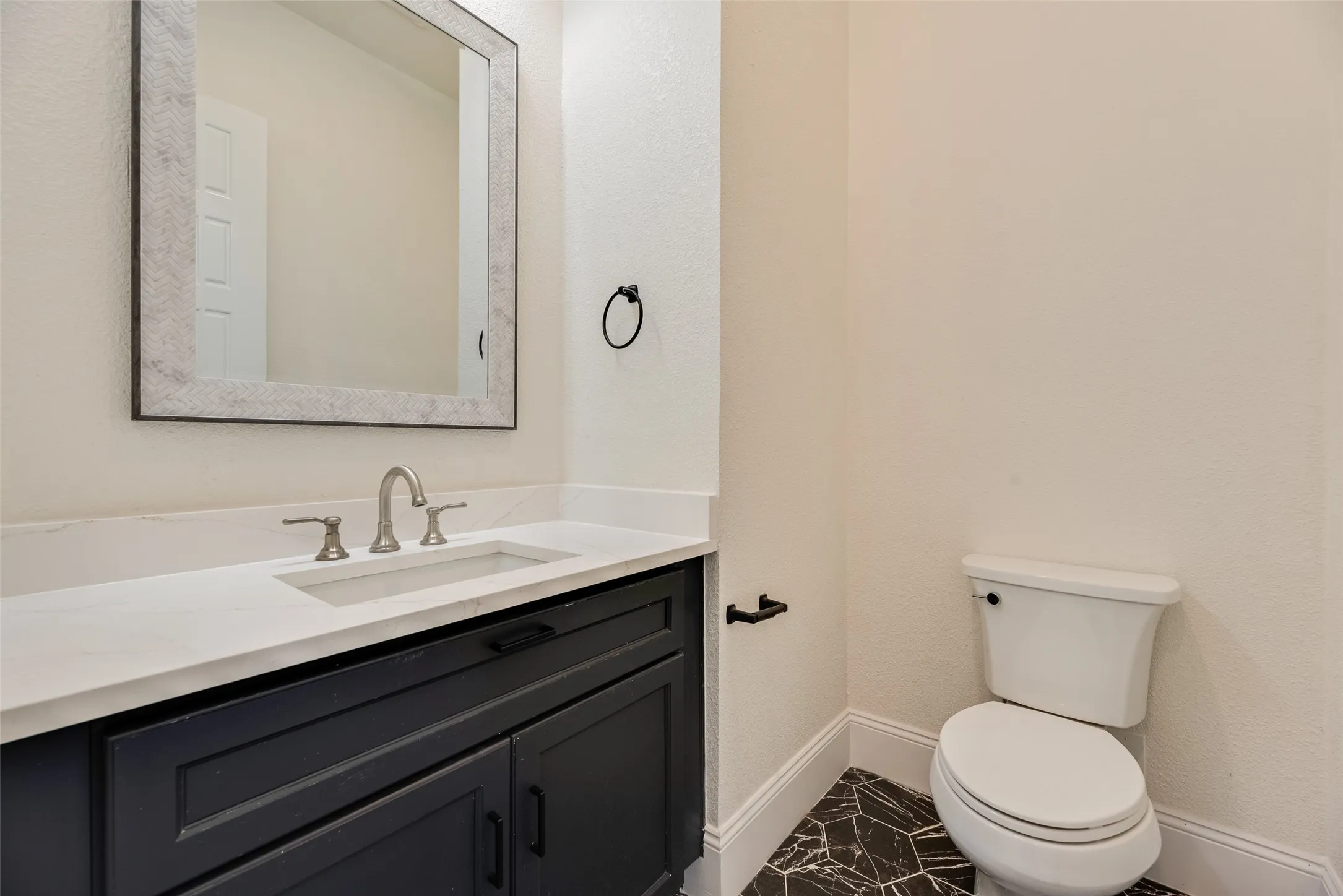 Vanity with a rectangular undermount sink, a three-piece faucet, and a custom framed mirror