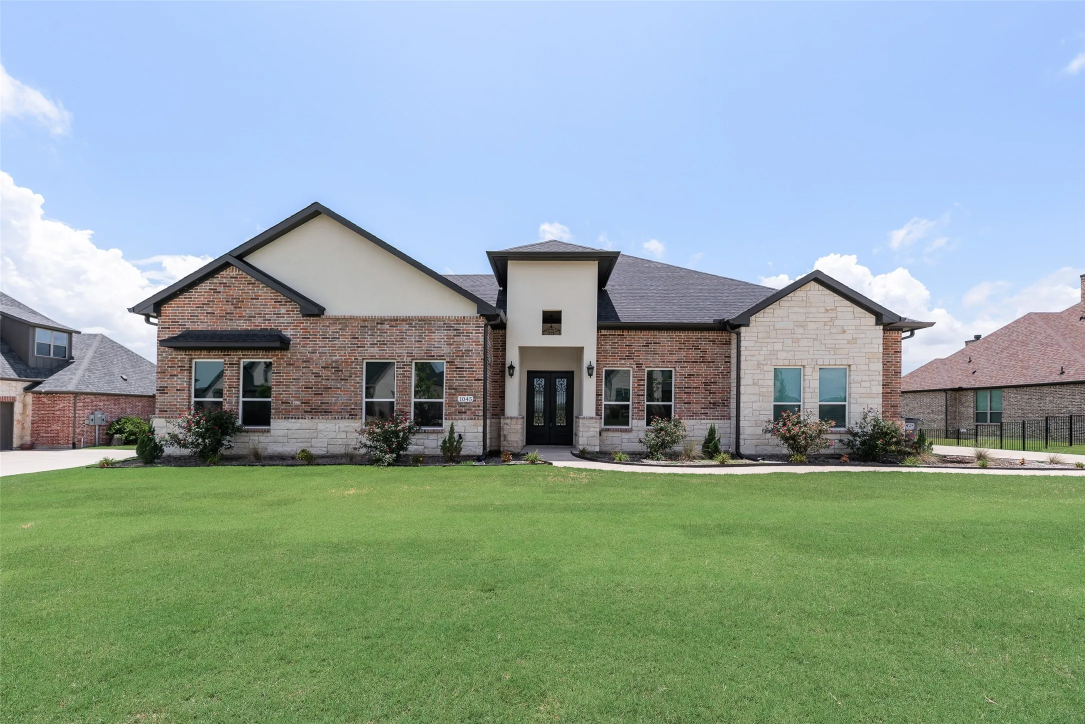 Brick and stone facade with a dark shingle roof