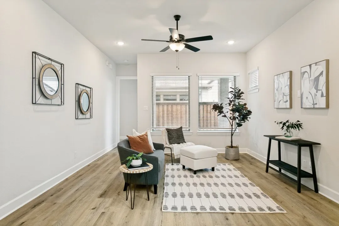 Spacious interior featuring wood-finish flooring, recessed lighting, a ceiling fan, and multiple windows with blinds