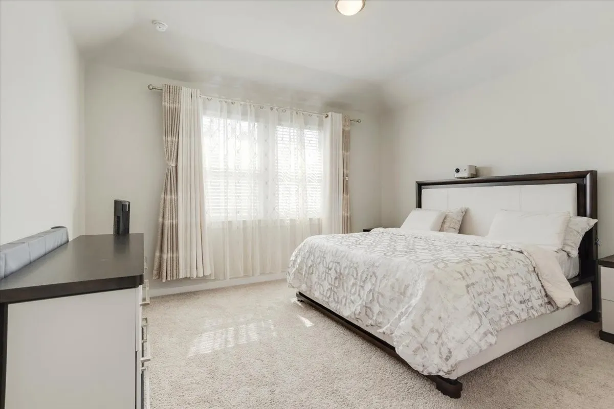 Carpeted flooring with a window featuring horizontal blinds