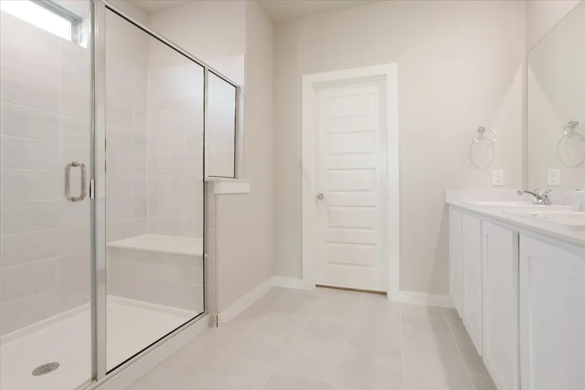 Glass-enclosed shower with a built-in bench