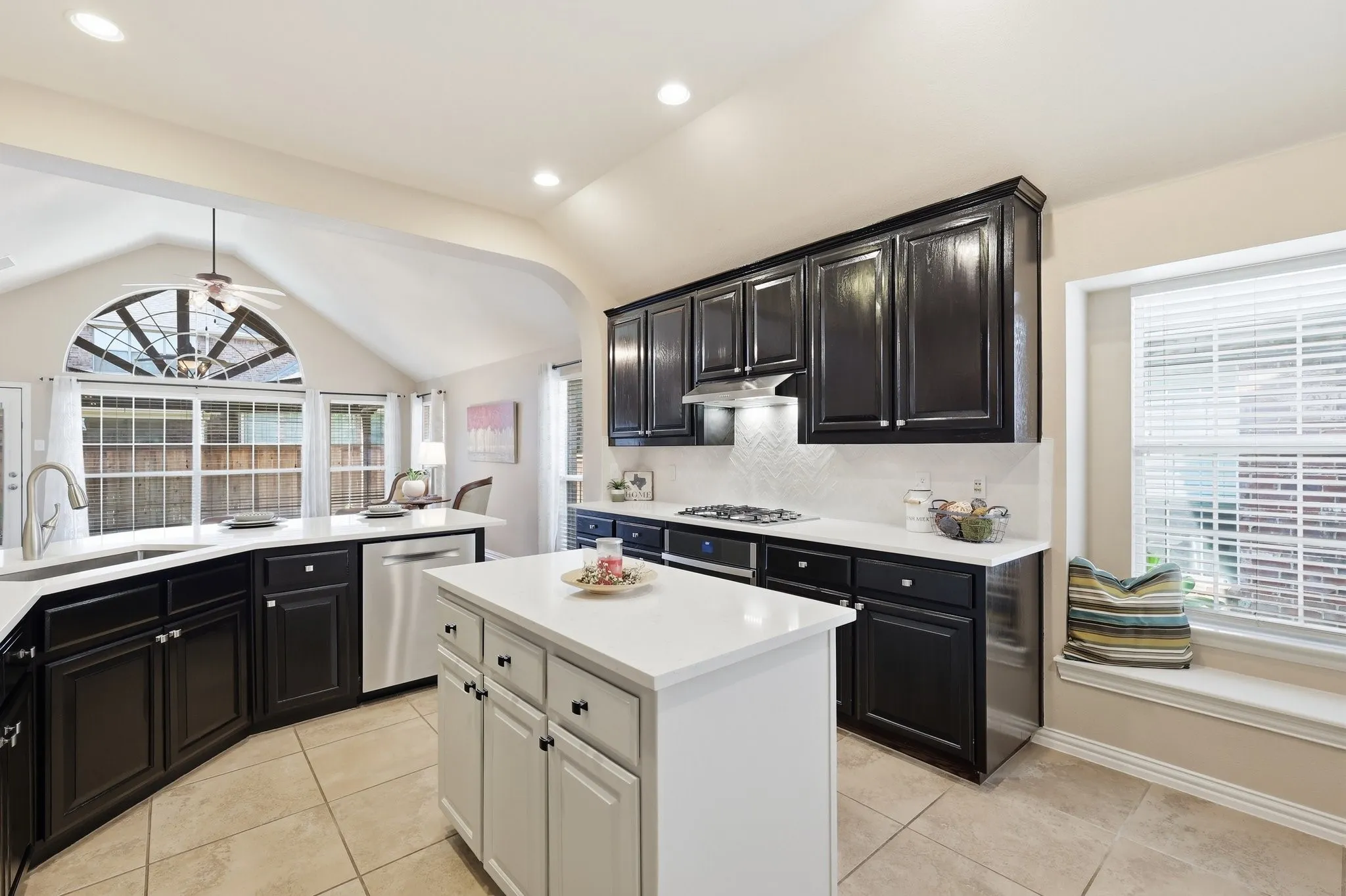 Kitchen featuring dark wood cabinetry, white countertops, stainless steel appliances, and a central​​‌​​​​‌​​‌‌​‌‌​​​‌‌​‌​‌​‌​​​‌​​ island