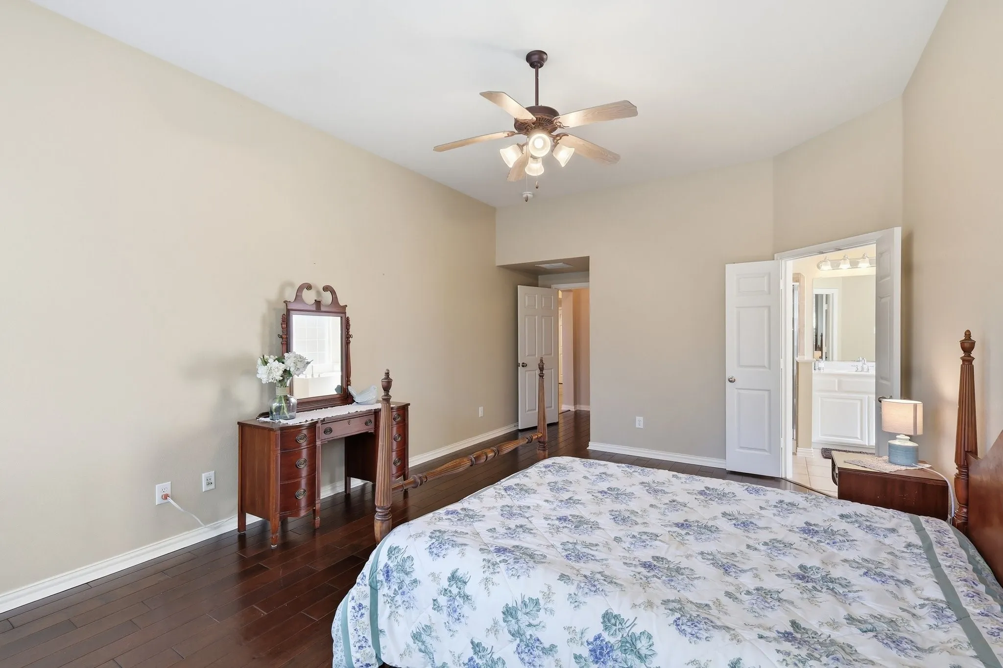 Wood-finish flooring, ceiling fan with integrated lighting, and neutral wall tones