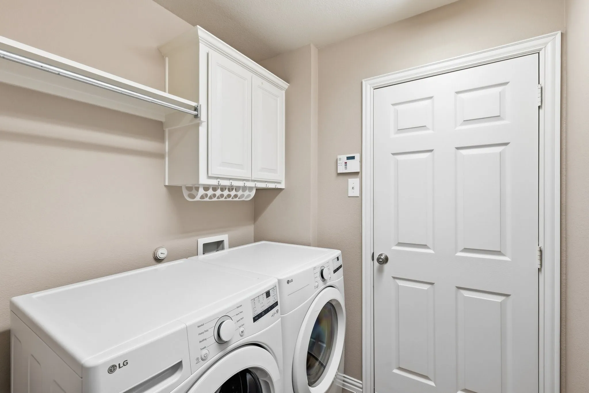 Built-in cabinetry, an integrated hanging rod, and a shelf provide organized utility