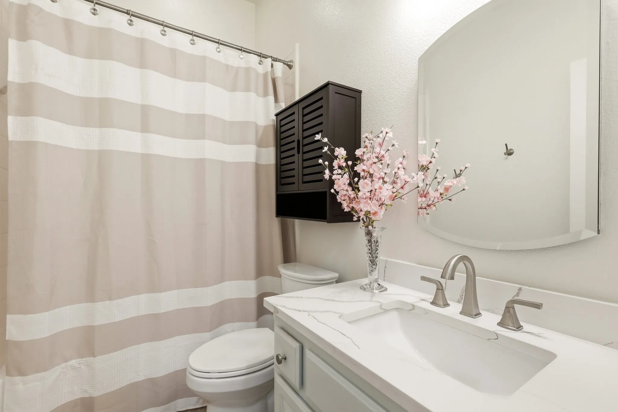 Downstair bathroom.Built-in vanity with light-toned cabinetry, a white countertop, and an undermount sink