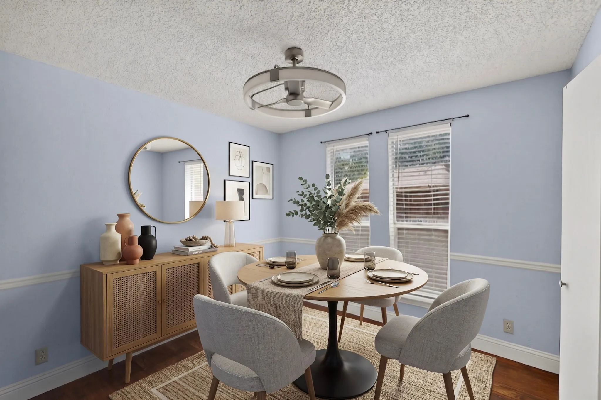 AI Staged Defined dining area featuring light blue walls with chair rail molding, two windows with blinds, a ceiling fan with integrated lighting, and wood-finish flooring