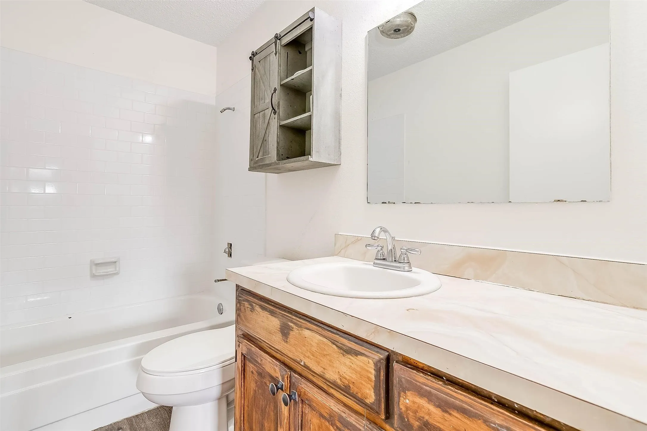 White subway tile tub surround with a built-in soap dish