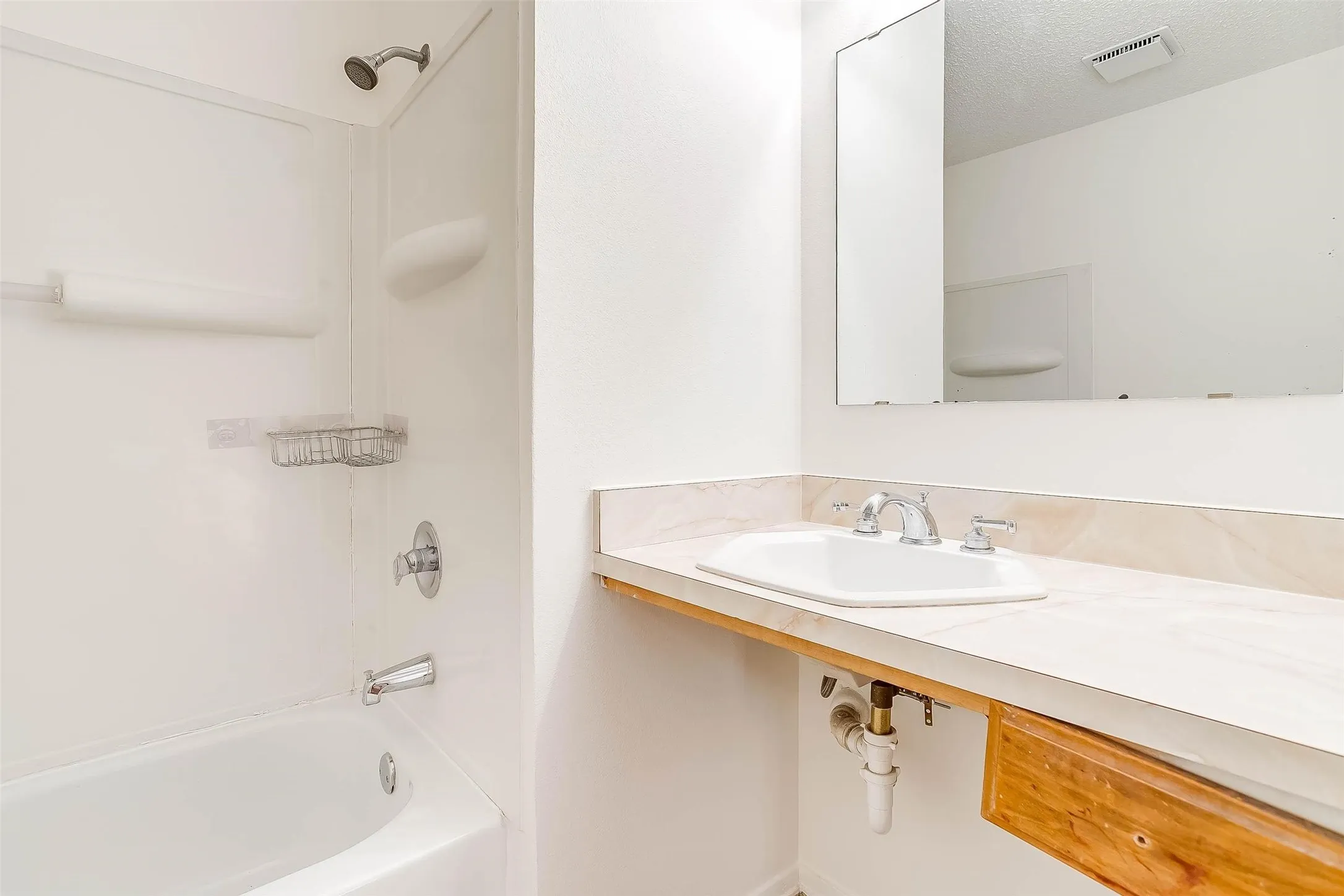White tub and shower combination with chrome fixtures