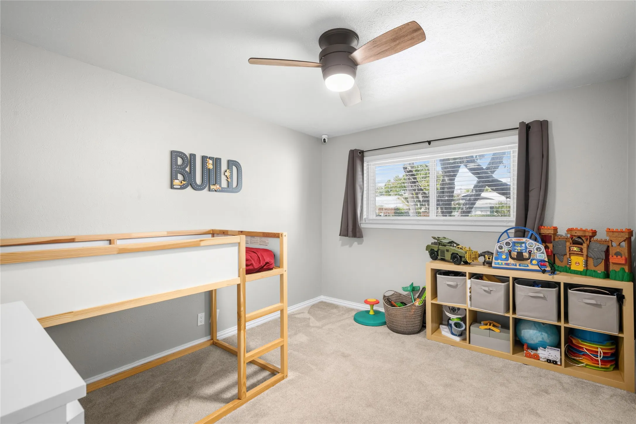 Neutral wall paint, light-colored carpeting, and a window with blinds