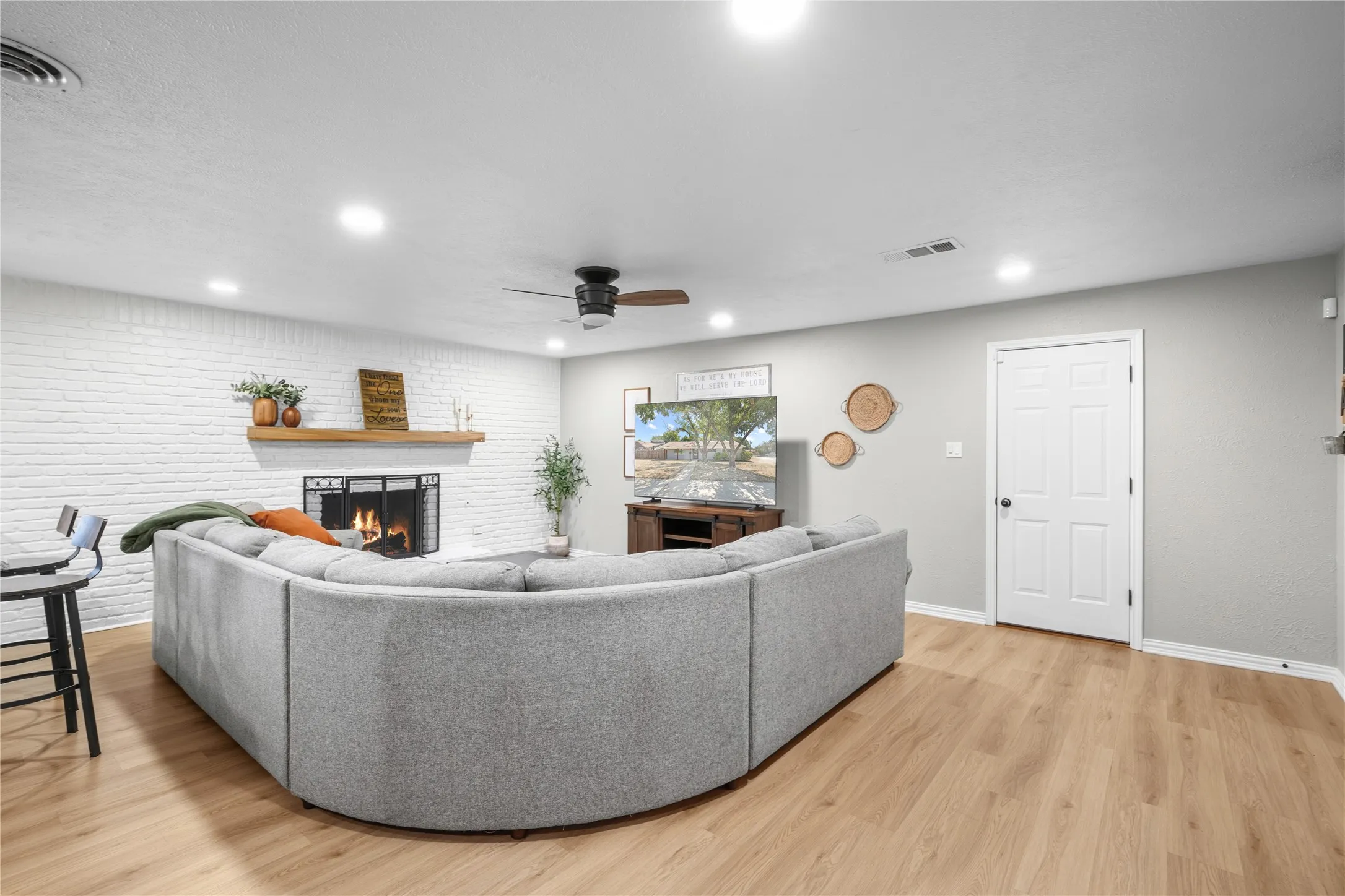 White painted brick fireplace with a wood mantel