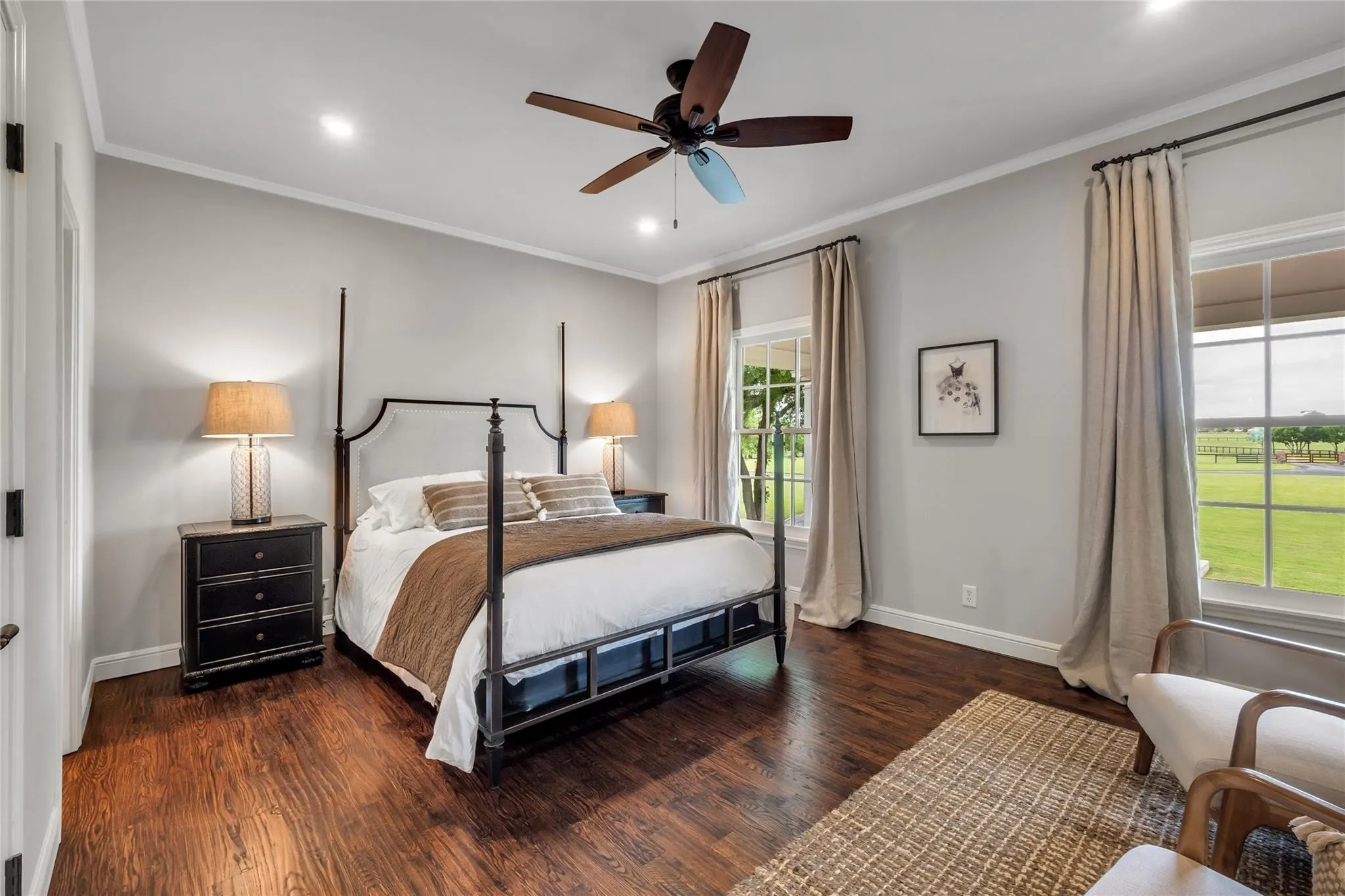 Rich wood-finish flooring with recessed lighting and a ceiling fan