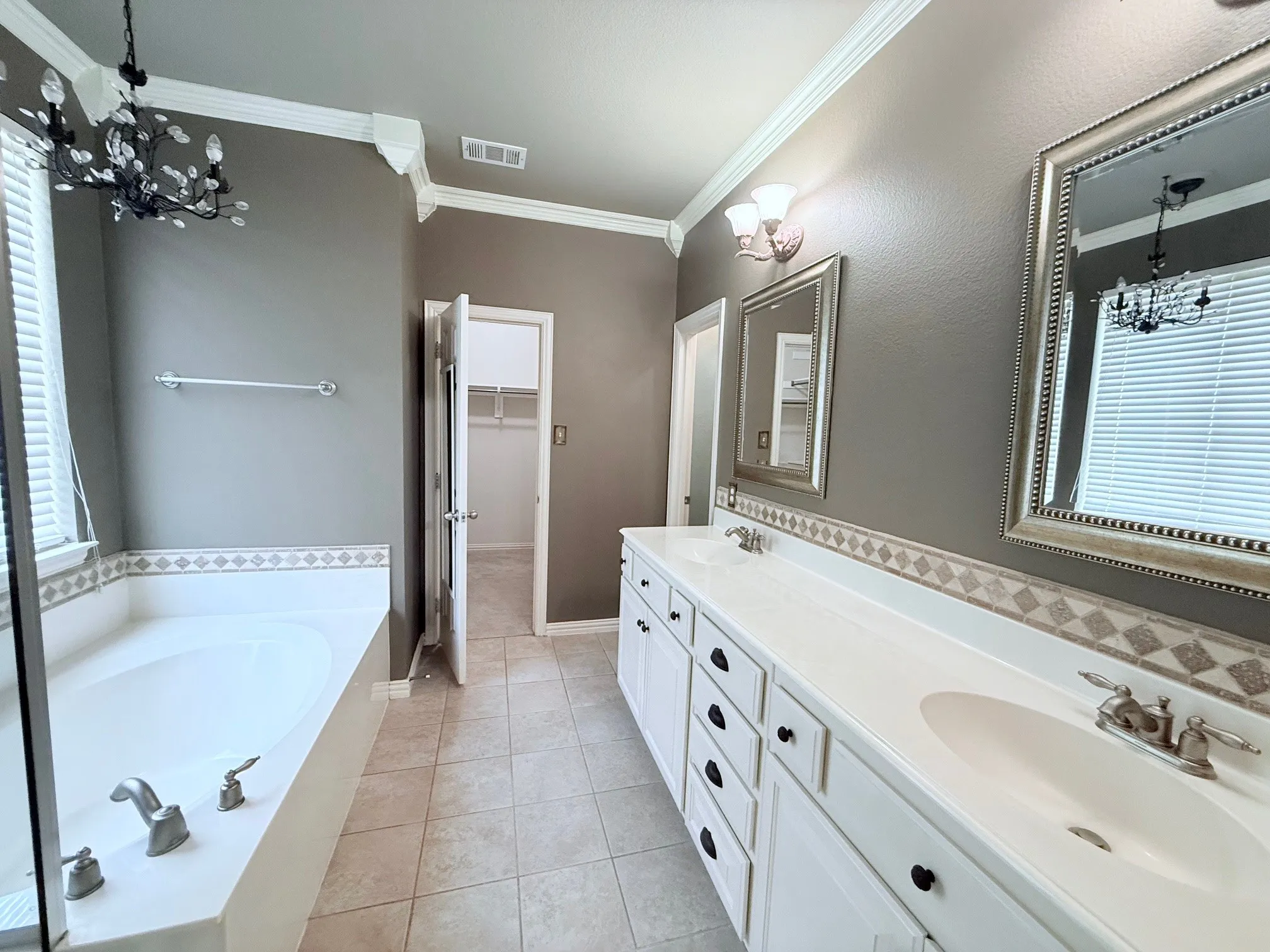 Dual sink vanity with white cabinetry and dark hardware