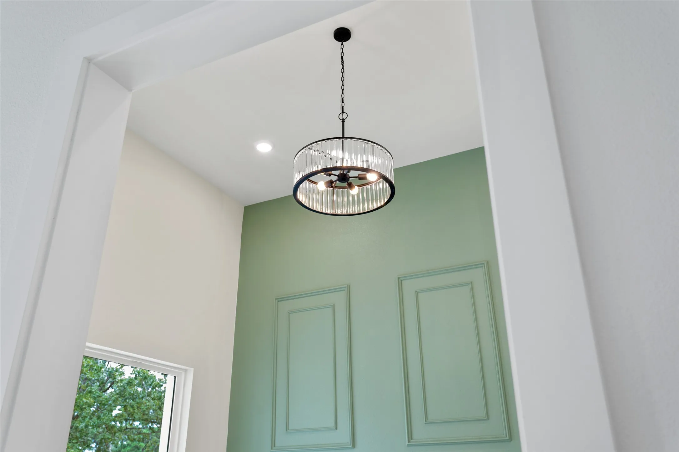 Vaulted ceiling with a contemporary chandelier and recessed lighting