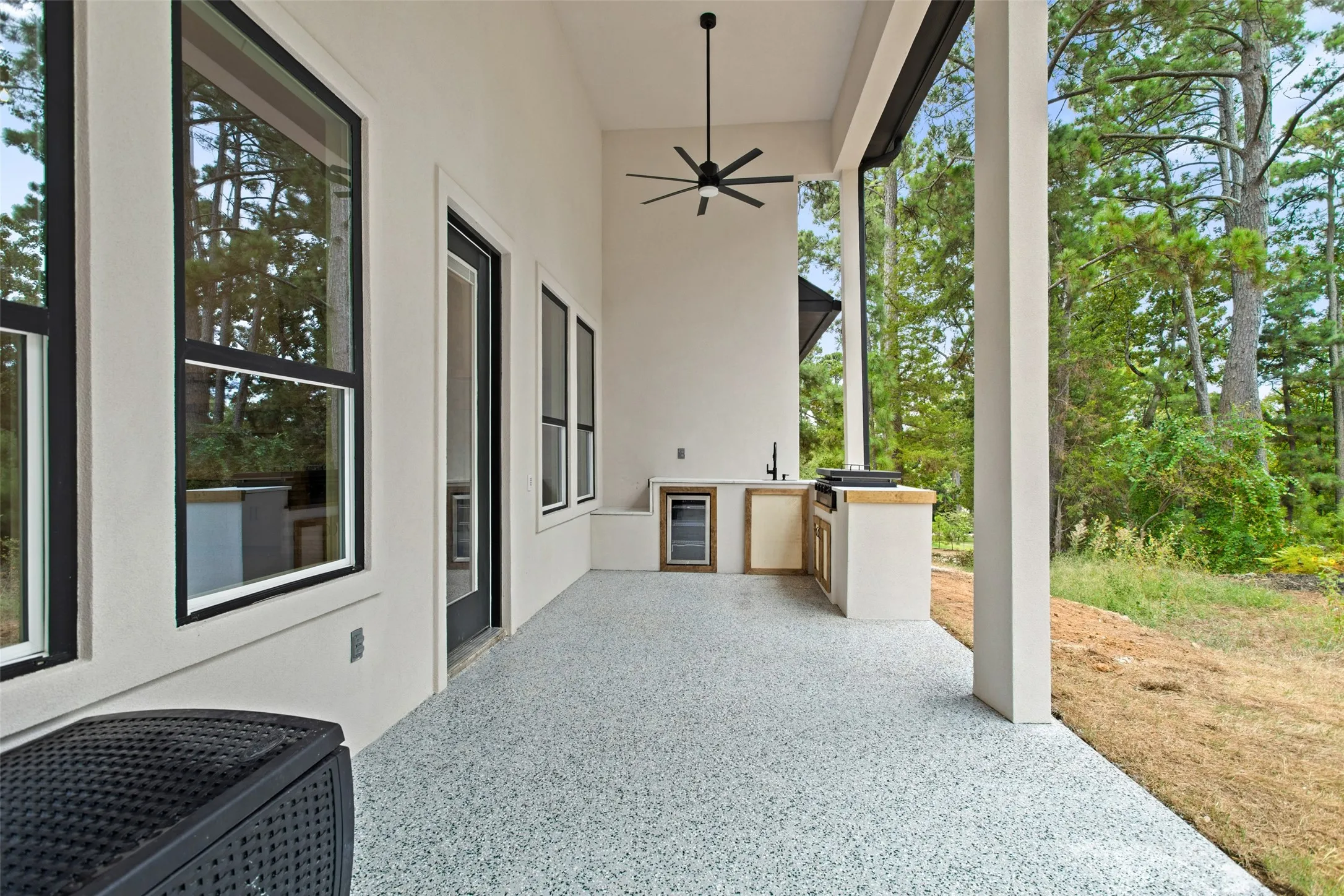 Spacious covered patio with a built-in outdoor kitchen, recessed lighting, and a ceiling fan